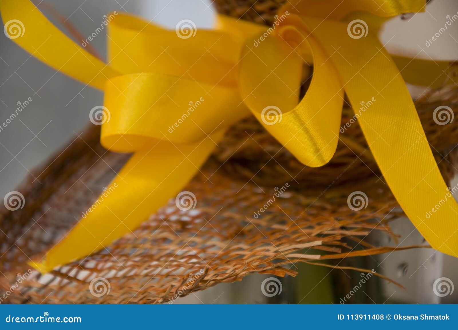 bright yellow bow and brown wicker flower wrapping. background