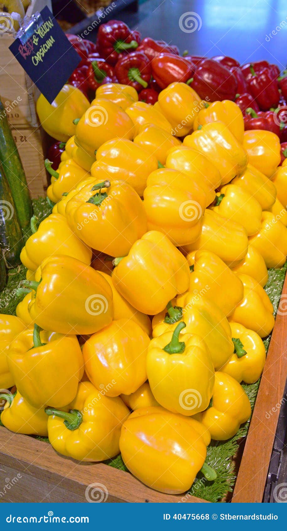 bright yellow capsicum with red ones in the background