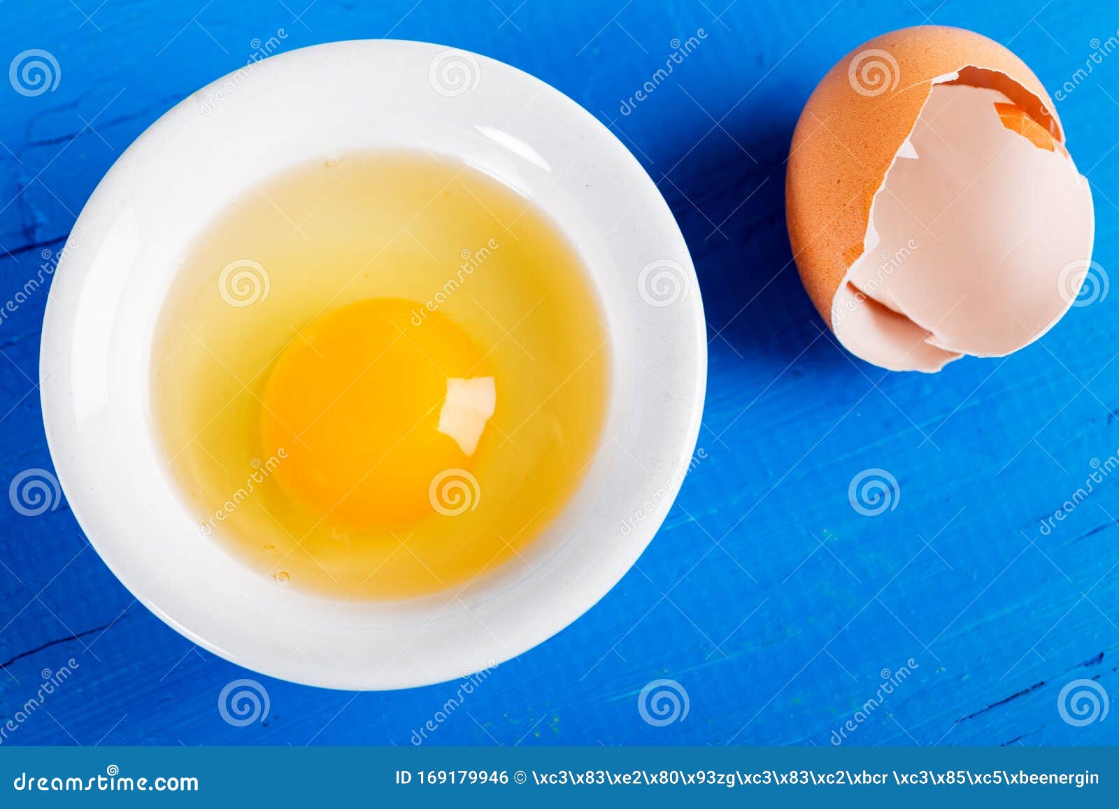 Bright Yellow Egg Yolk In White Bowl On Old Wooden Table Stock Photo Image Of Life Background 169179946
