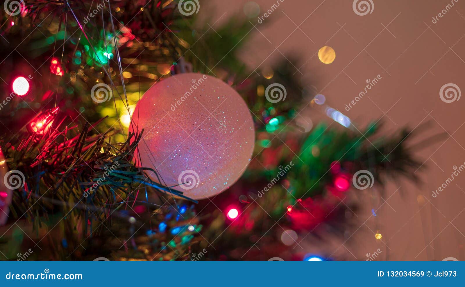 Brightly Colored, Cheery Christmas Tree Ornaments Hung Up with Lights