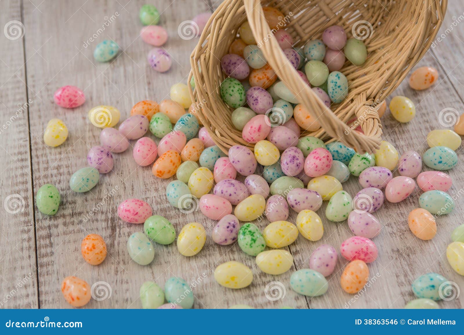 Brightly Colored Easter Egg Candy Spilling from Wicker Basket Stock