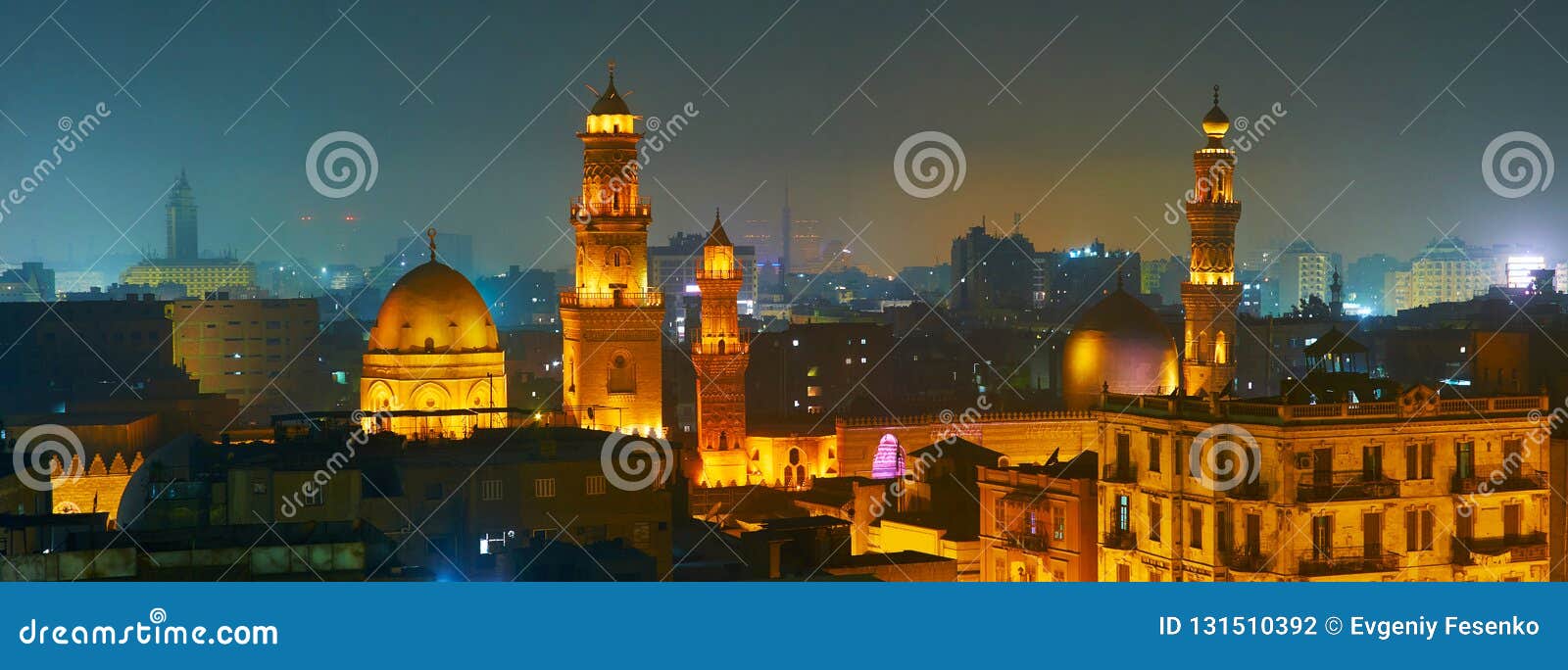 the brightly illuminated domes and minarets of sultan qalawun, al moez and elzaher barqooq mosques in dark evening sky of cairo,