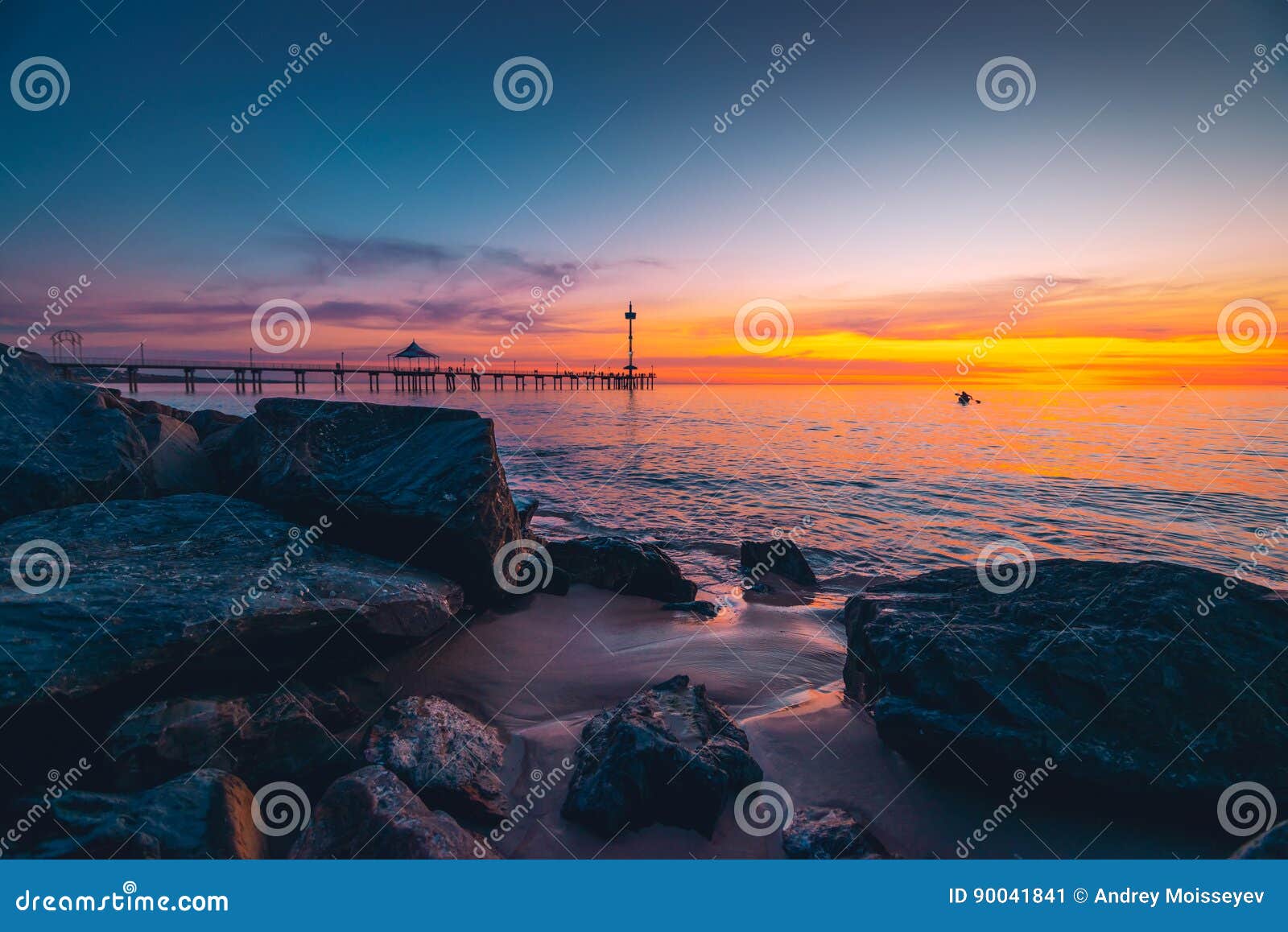 Brighton Jetty con la gente al tramonto. La gente che cammina lungo Brighton Jetty al tramonto Australia Meridionale