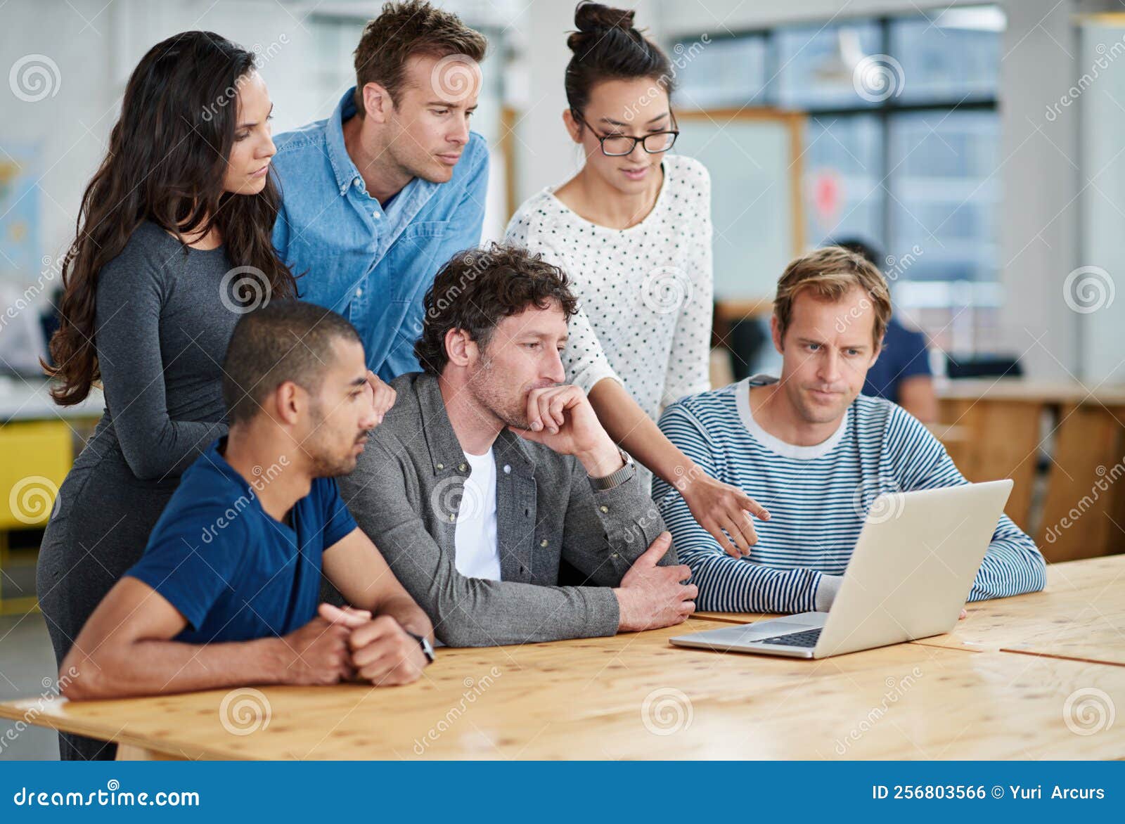 Bringing Many Ideas To the Table. a Group of Colleagues Using a Laptop