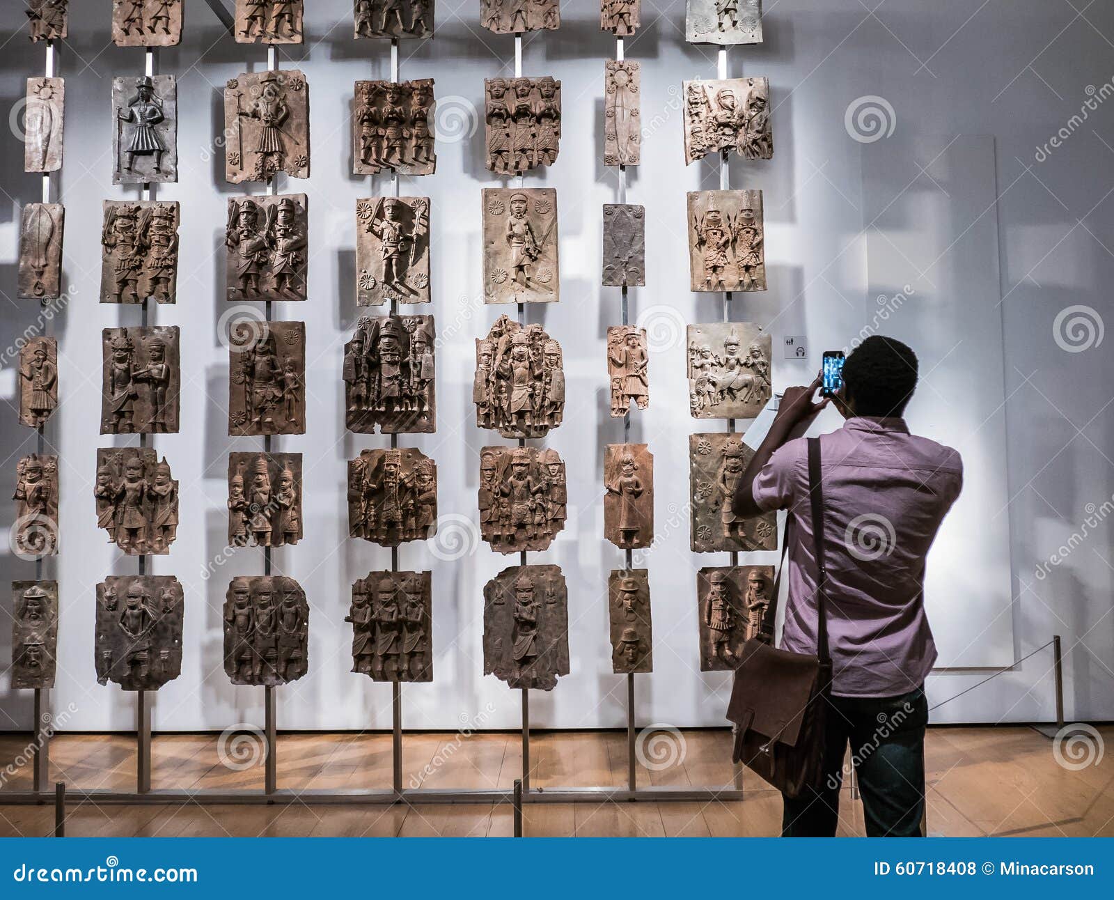 British Museum-de bezoeker fotografeert Benin plaques van Nigeria. Londen, Engeland, 22 Augustus, 2015: British Museum-de bezoeker fotografeert Benin plaques van 16de eeuw Nigeria