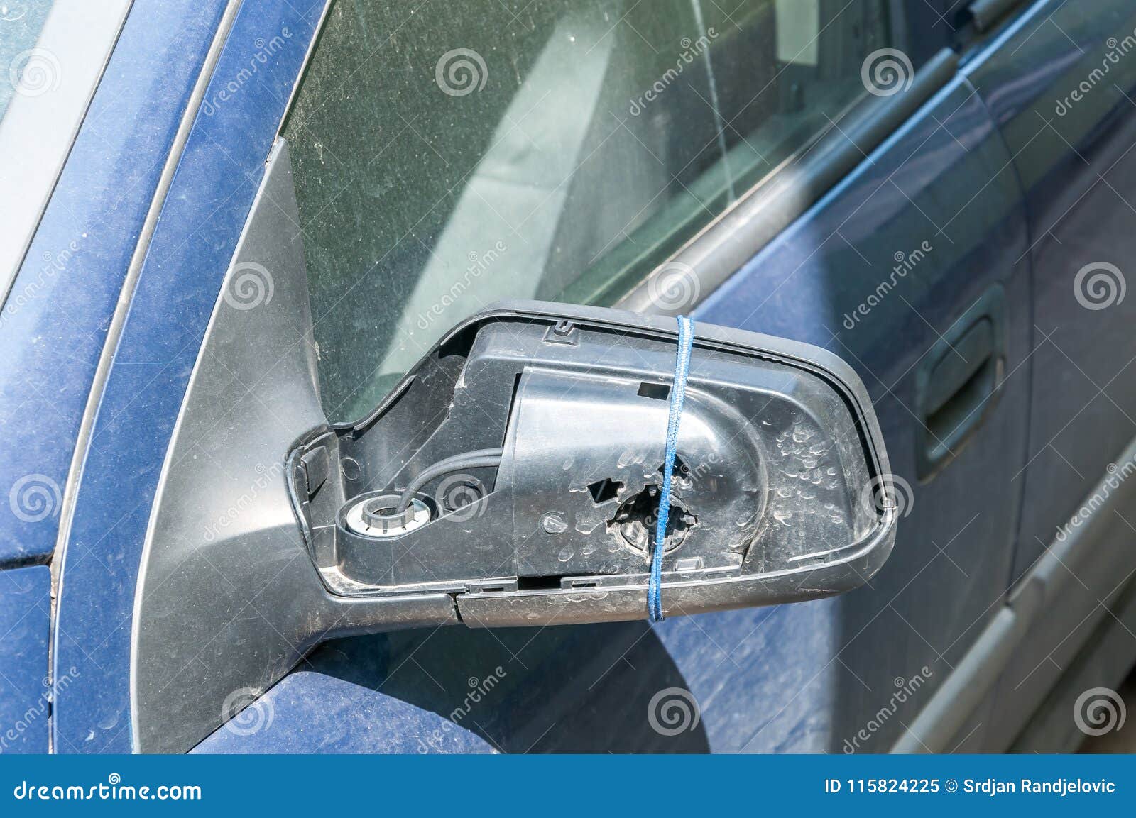Broken and Damaged Side Mirror on the Blue Car Doors with Remaining