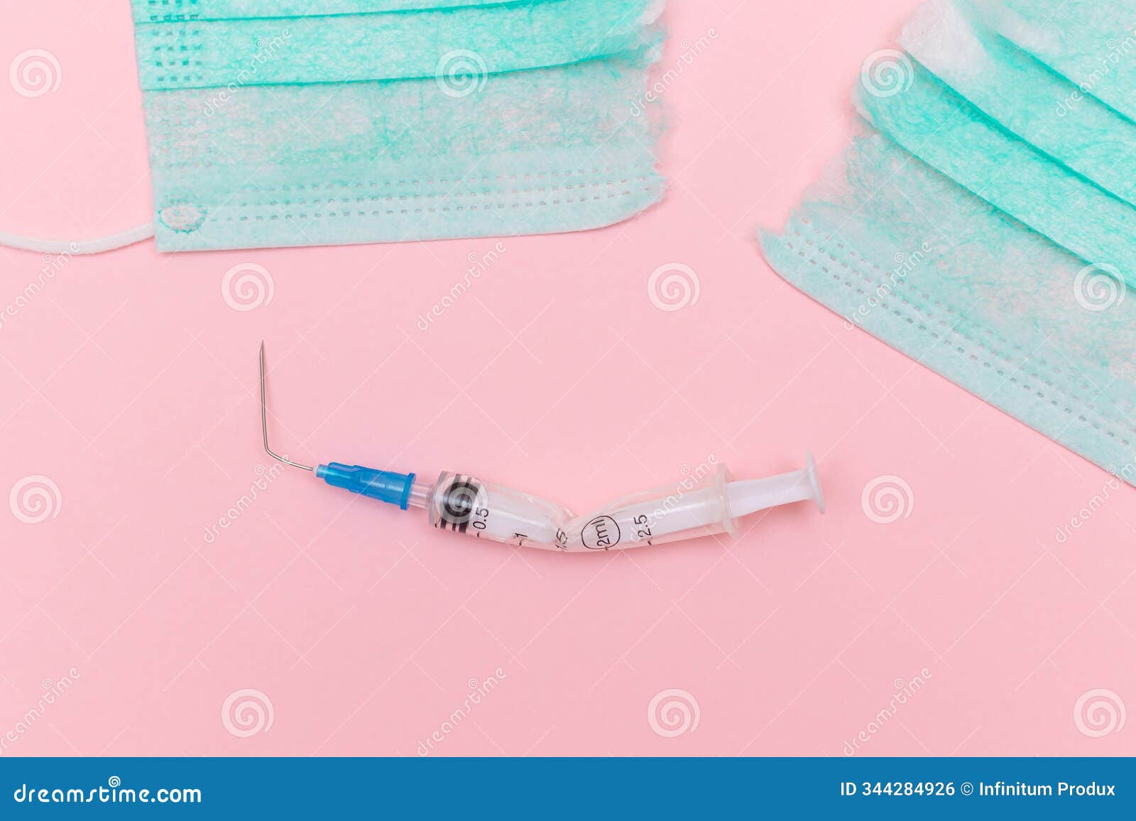 broken medical syringe and torn medical face mask on the pink background