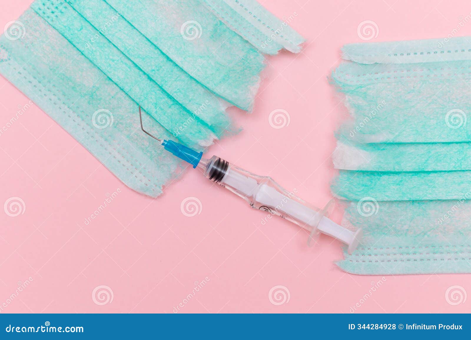 broken medical syringe and torn medical face mask on the pink background
