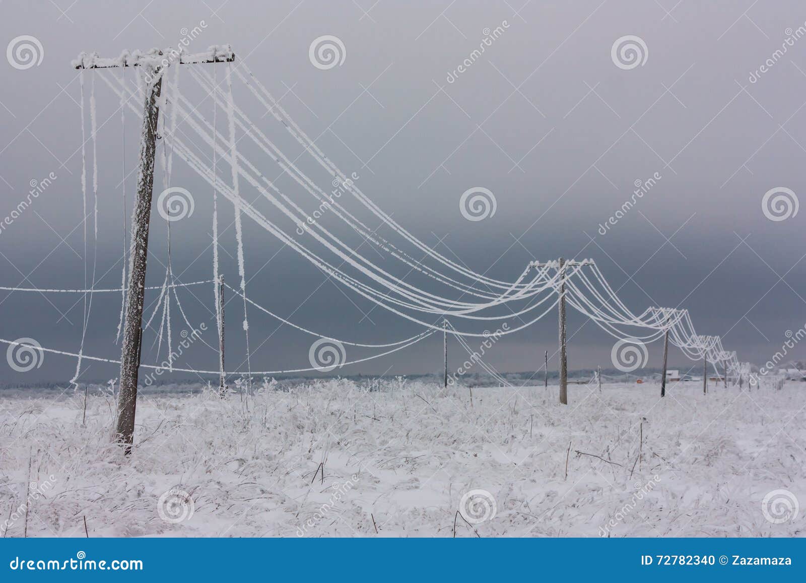 broken phase electrical power lines with hoarfrost on the wooden electric poles on countryside in the winter after storm