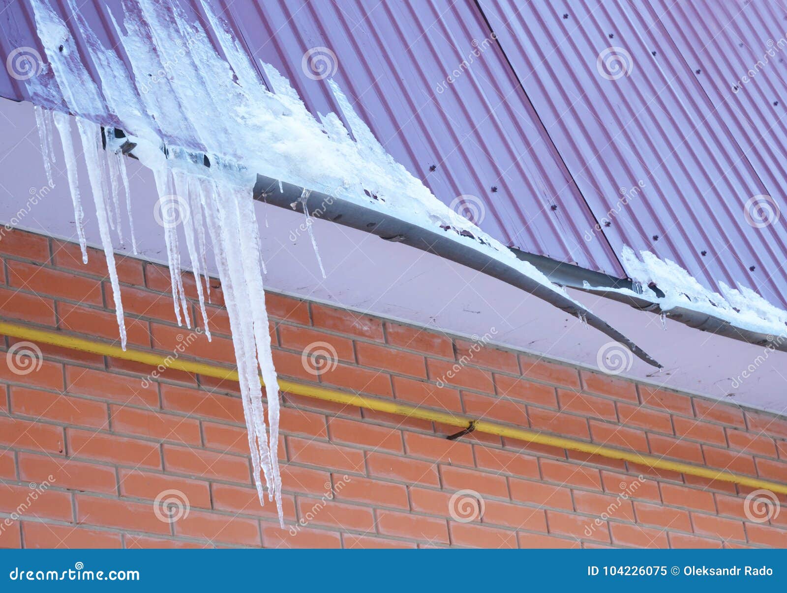 broken rain gutters. ice dam. closeup on new broken rain gutter system without roof protection snow guard on house construction.