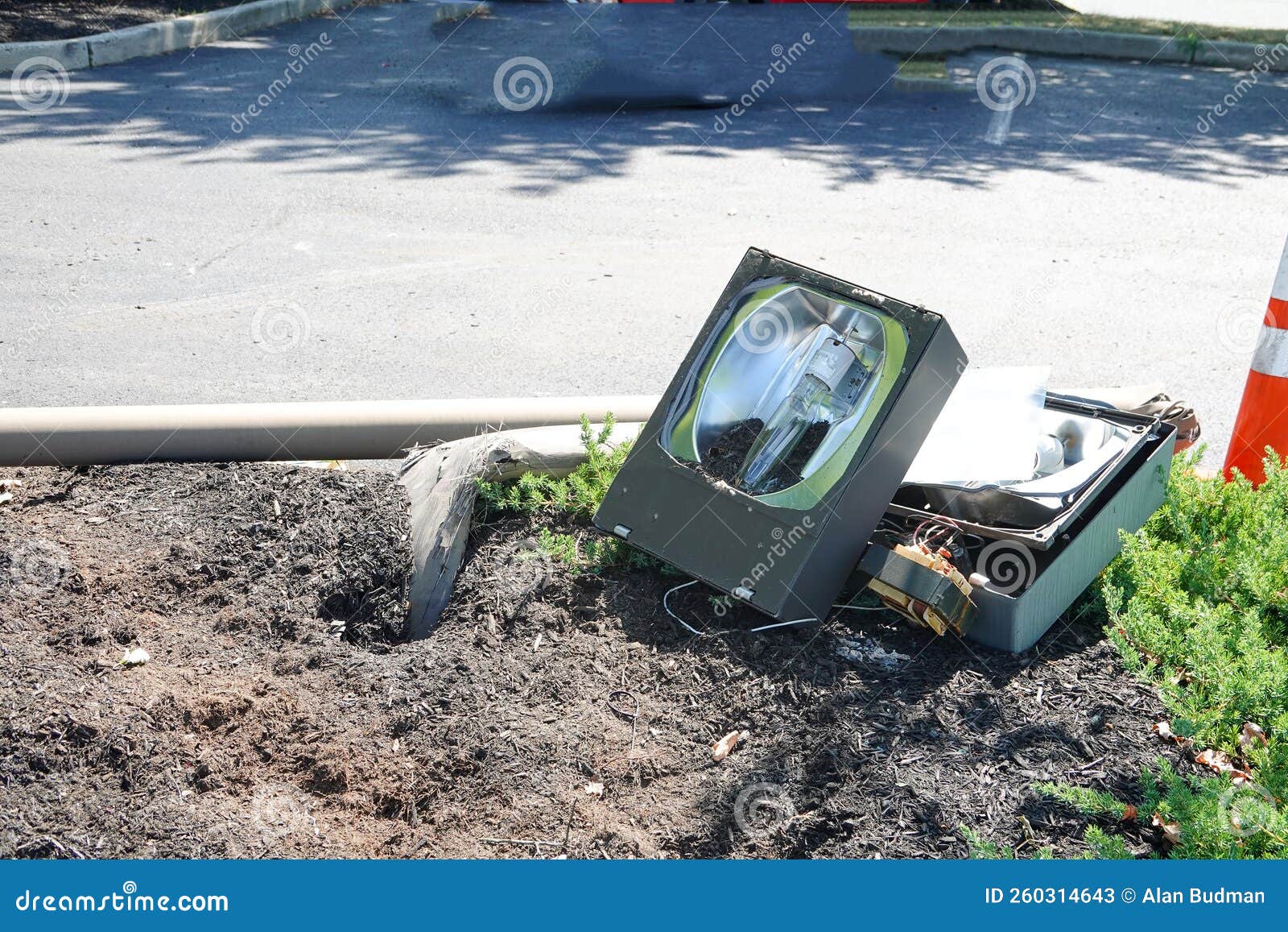 Broken Street Light Laying on the Ground in a Parking Lot Stock Image