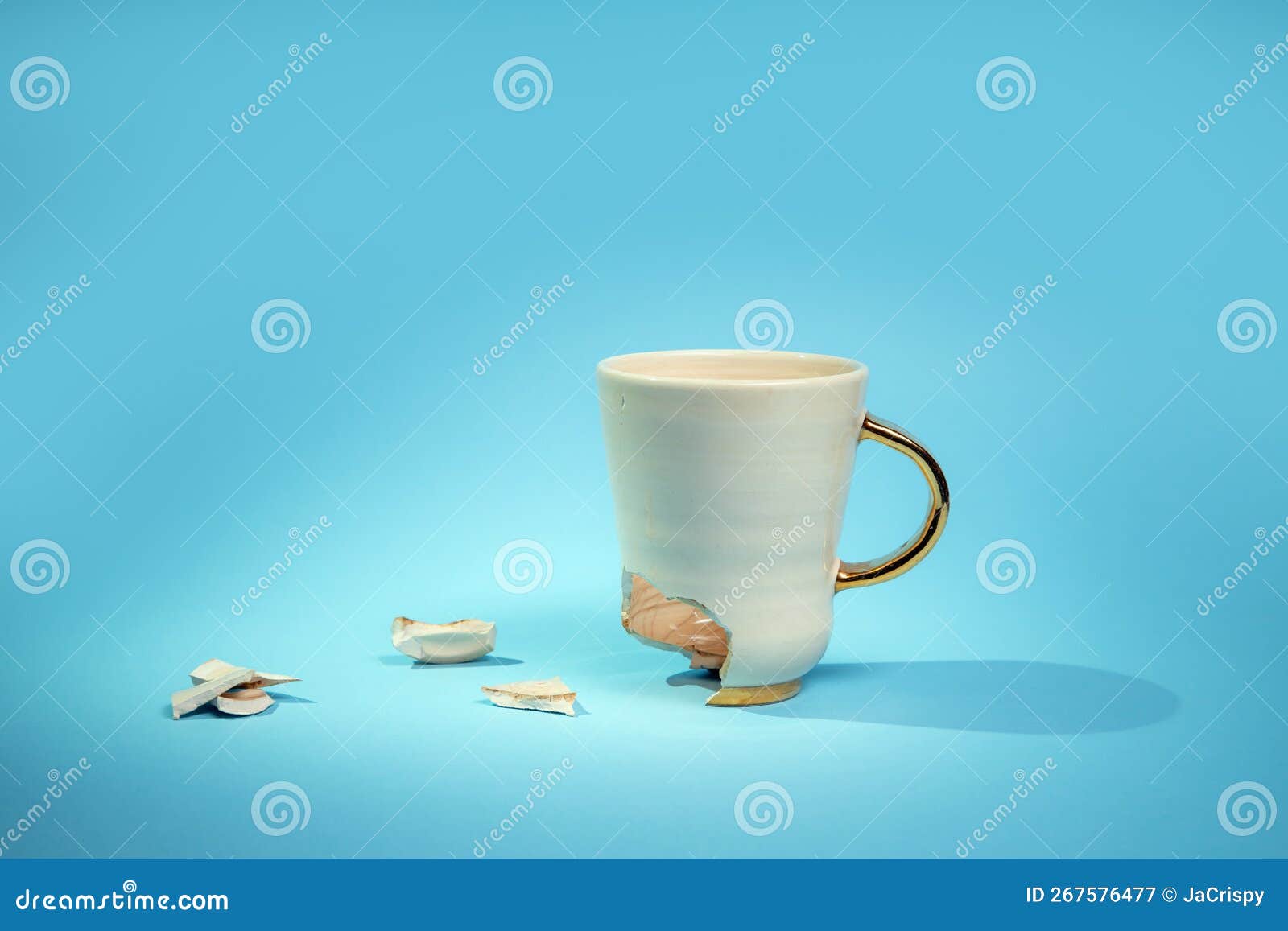 Broken Tea Cup Isolated on Blue Background. Cracked Coffee Mug and