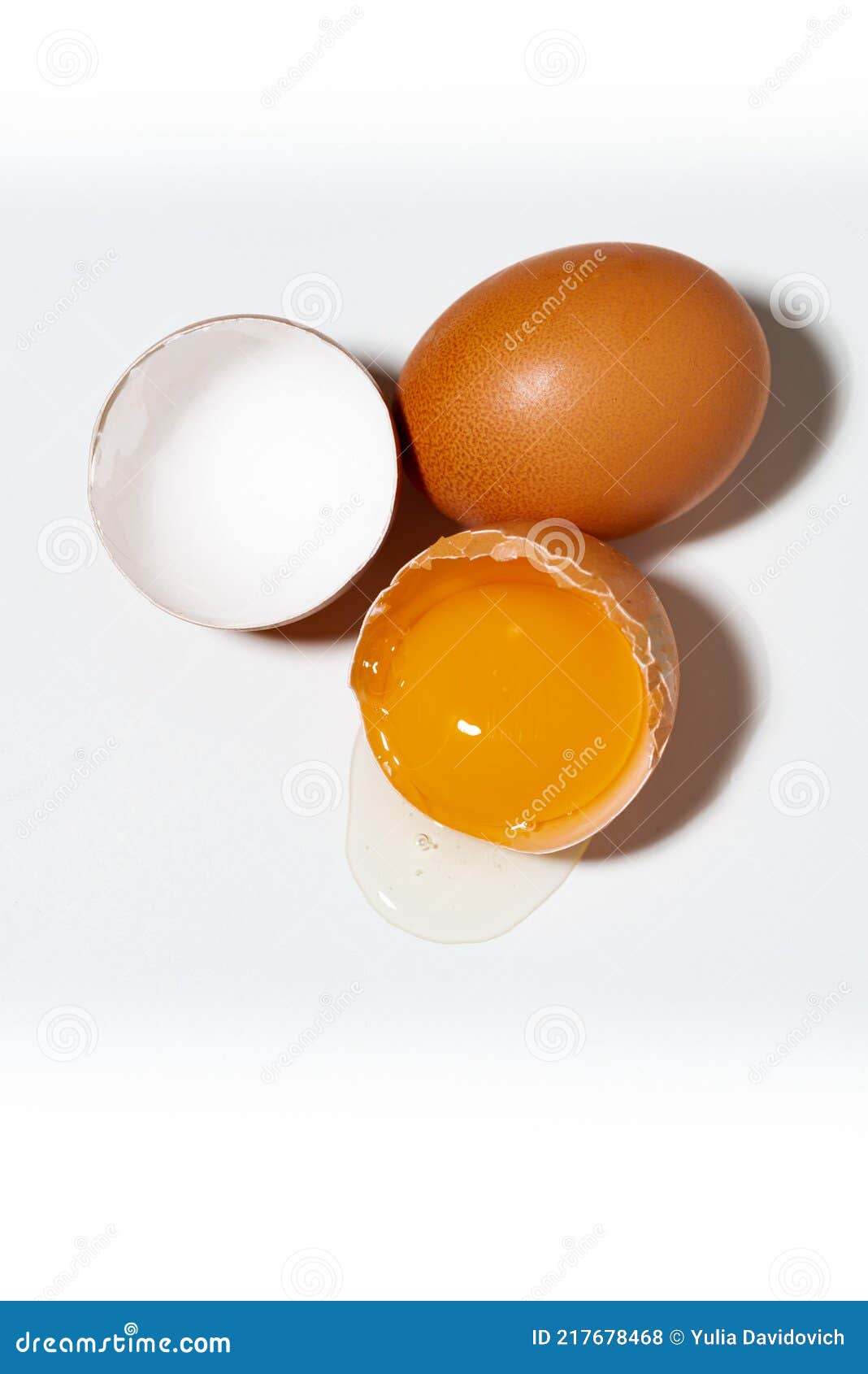 Broken and Whole Chicken Egg on White Background, Vertical Top View