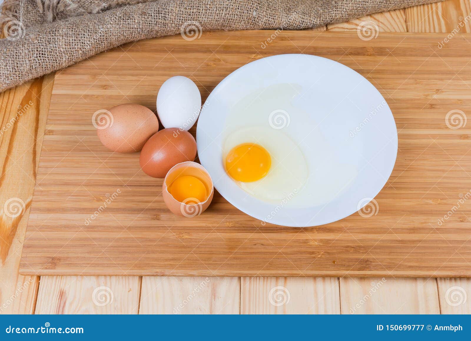 Broken and Whole Eggs on Cutting Board on Rustic Table Stock Image