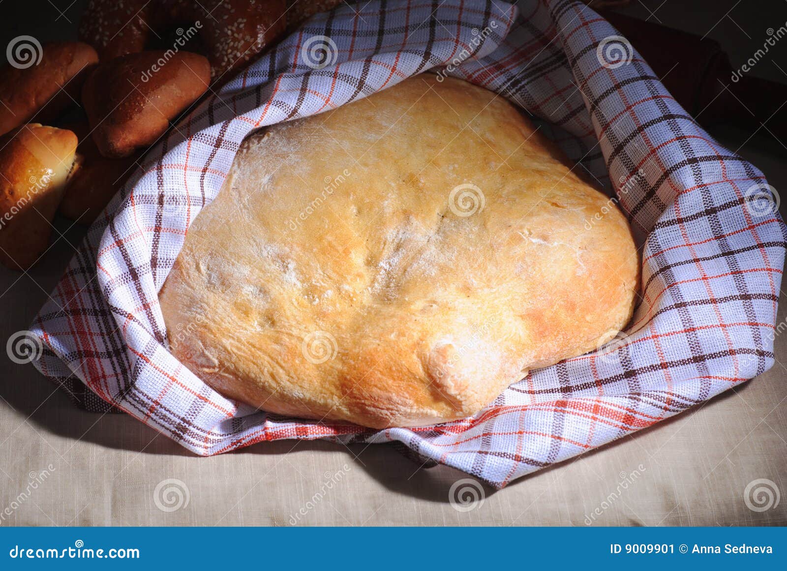 Brood van eigengemaakt brood. Met een witte handdoek die een deel van het behandelt.