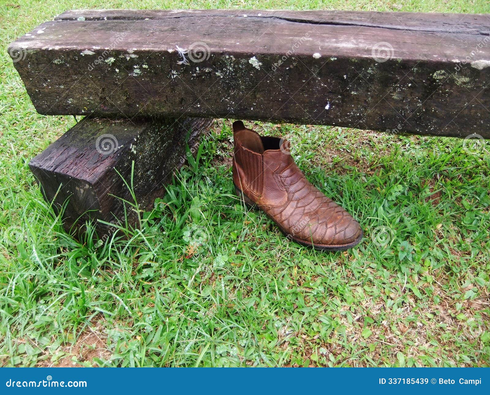 brown boot under a wooden bench, green grass in the tourist town of santo antonio de pinhal