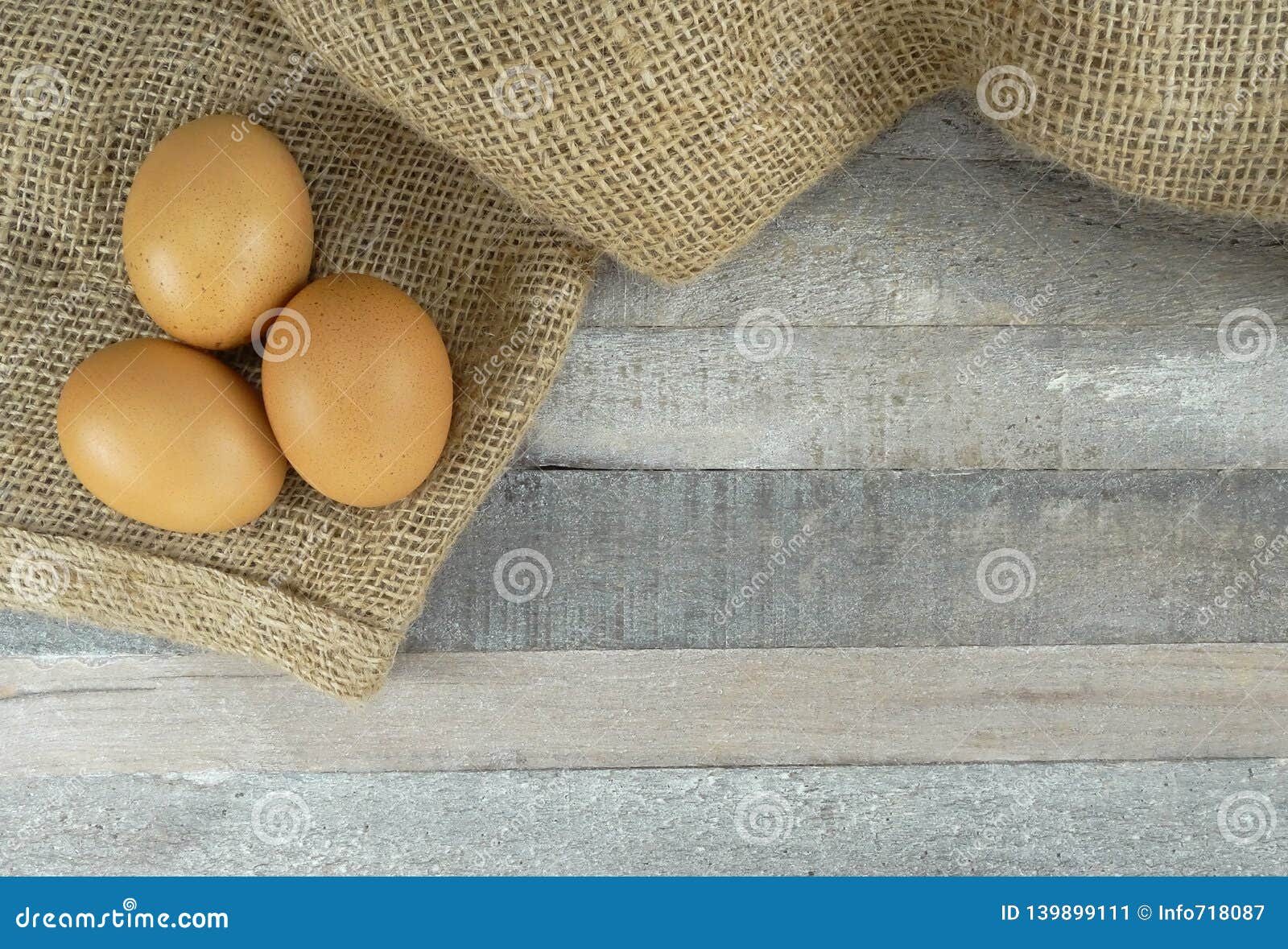 brown chicken eggs on burlap over wooden background