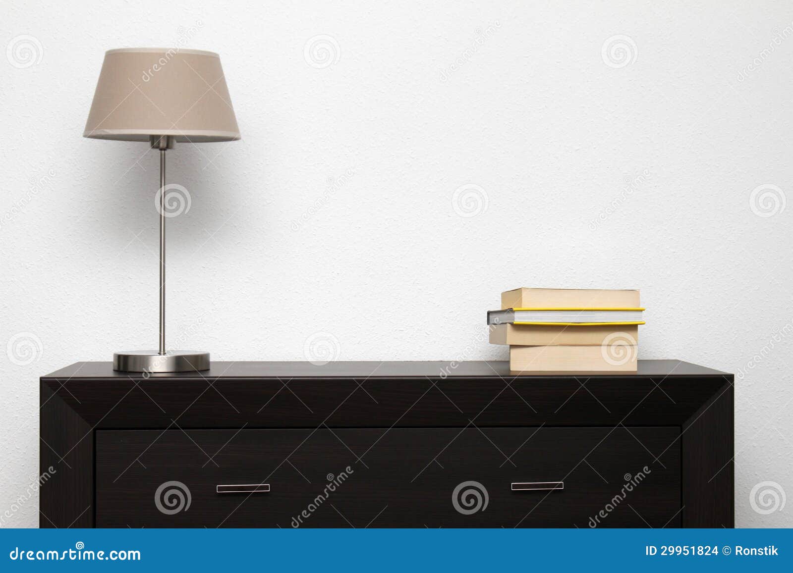 brown commode with lamp and books in minimalism interior