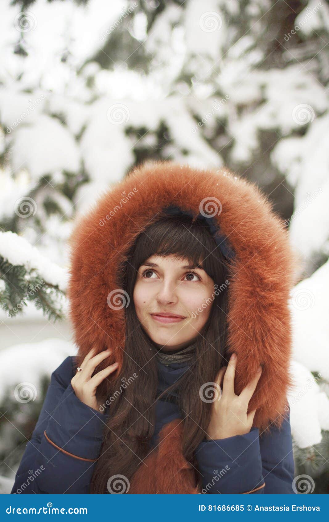 Brown-haired Girl In The Hood With Fur Smiling On A Background Of Snow ...