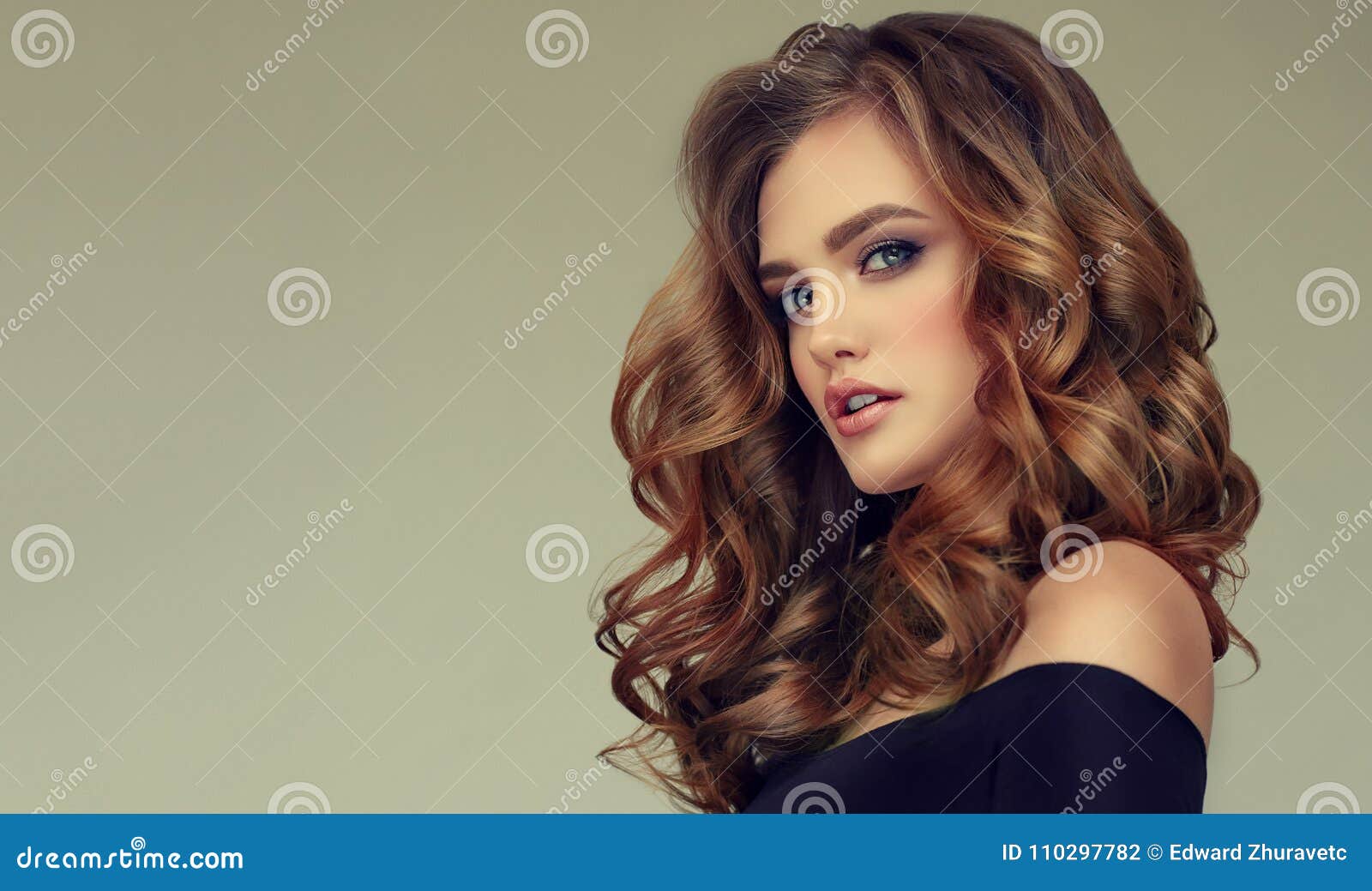 brown haired woman with voluminous, shiny and curly hairstyle.frizzy hair.