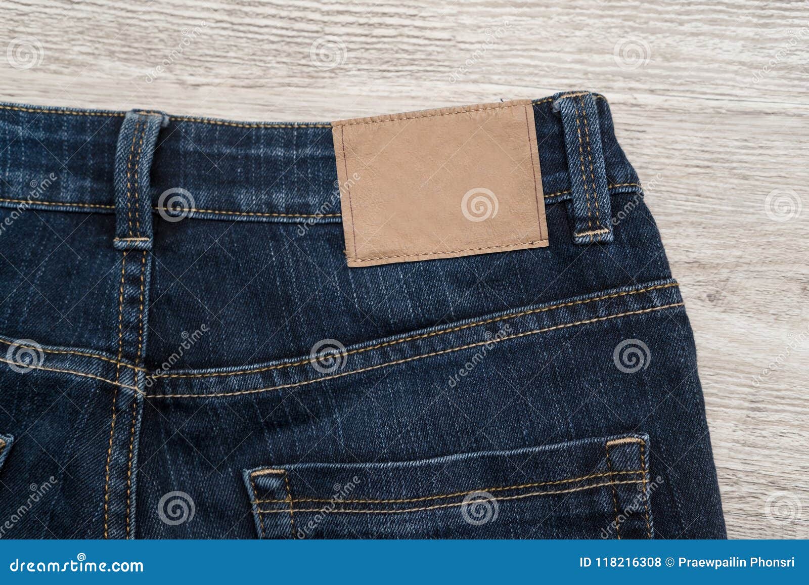 Brown Leather Label of Blue Jeans on Back of Jean with Wood Background ...