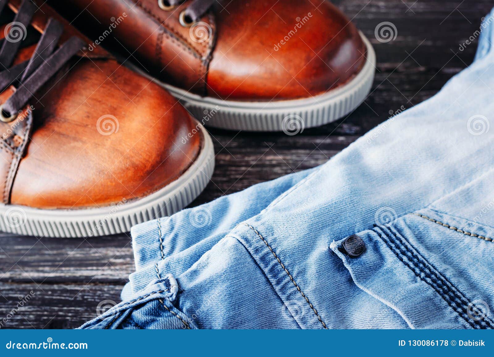 Brown Leather Men`s Boots and Blue Jeans on a Dark Wooden Background ...