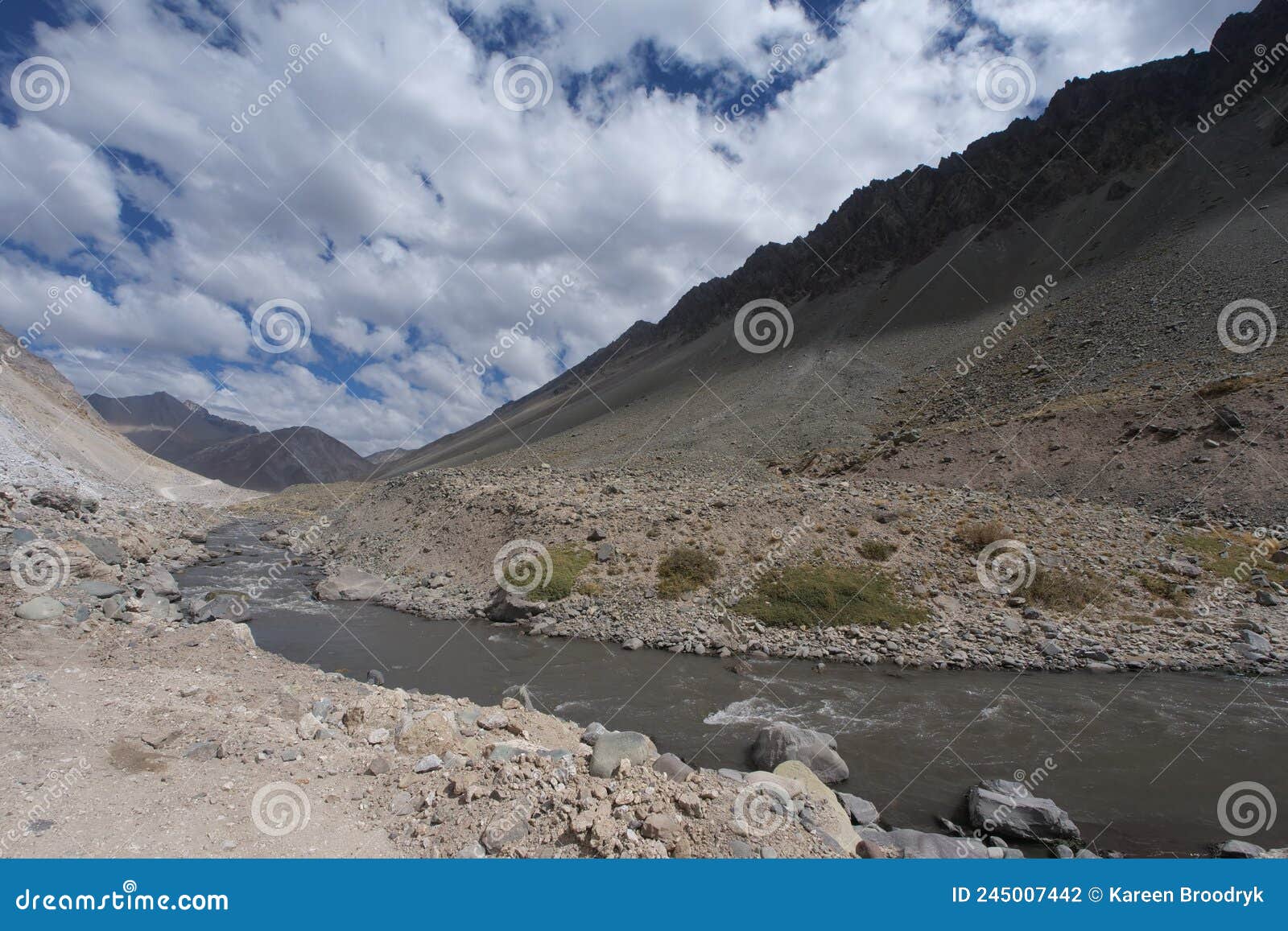brown river running through the valle de colina, andes mountain range, chile, south america