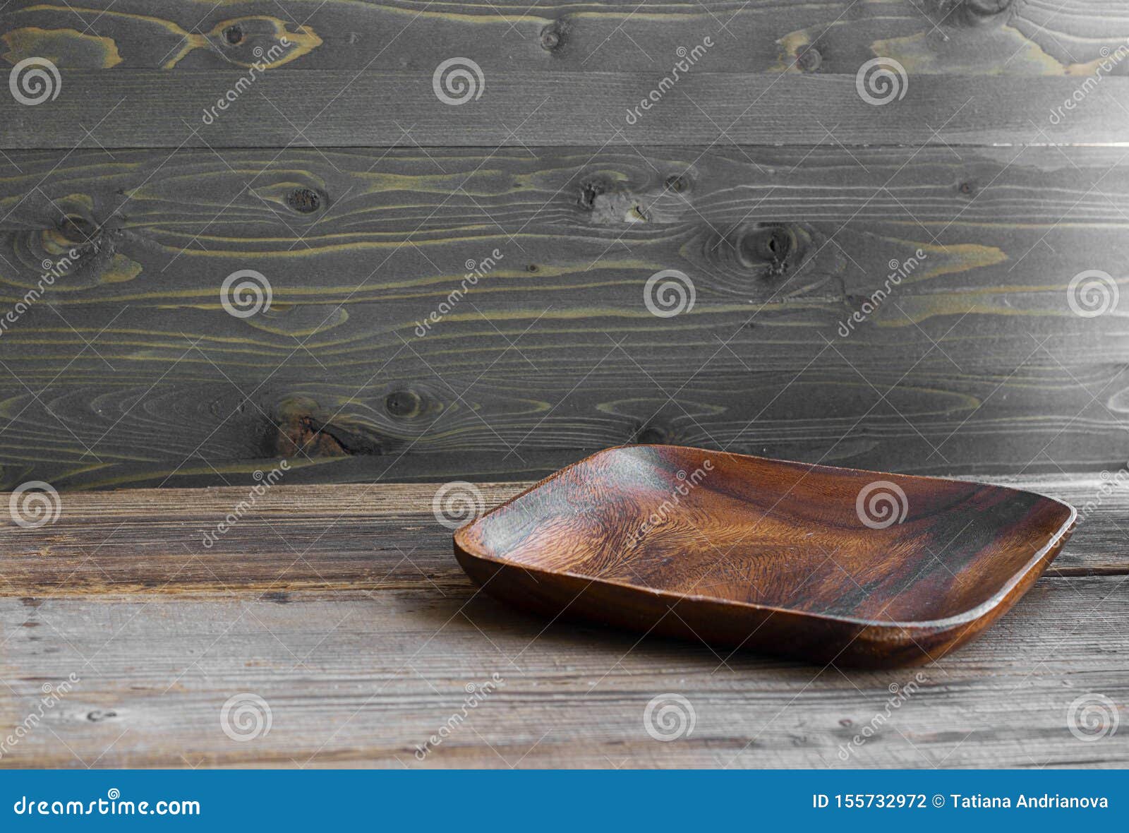 brown square flat wooden empty plate on the texutred natural table made from timber. normal angle. horizontal with copy