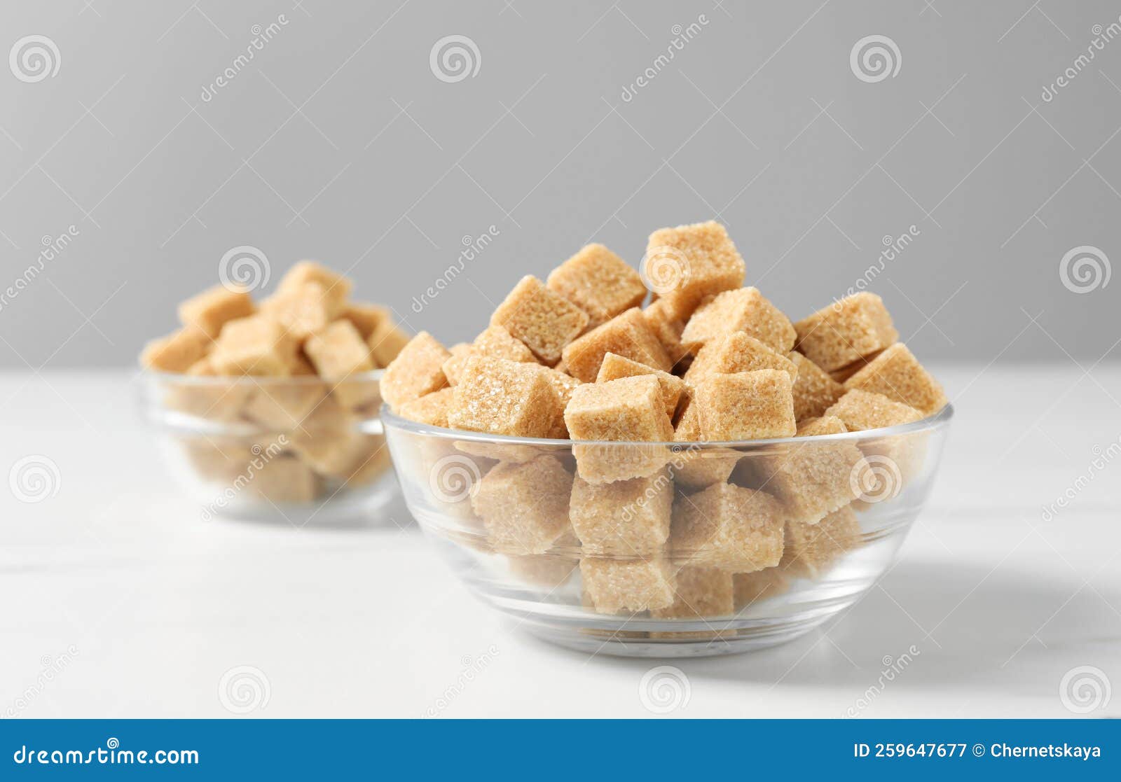 Brown Sugar Cubes in Glass Bowl on White Table, Closeup Stock Image