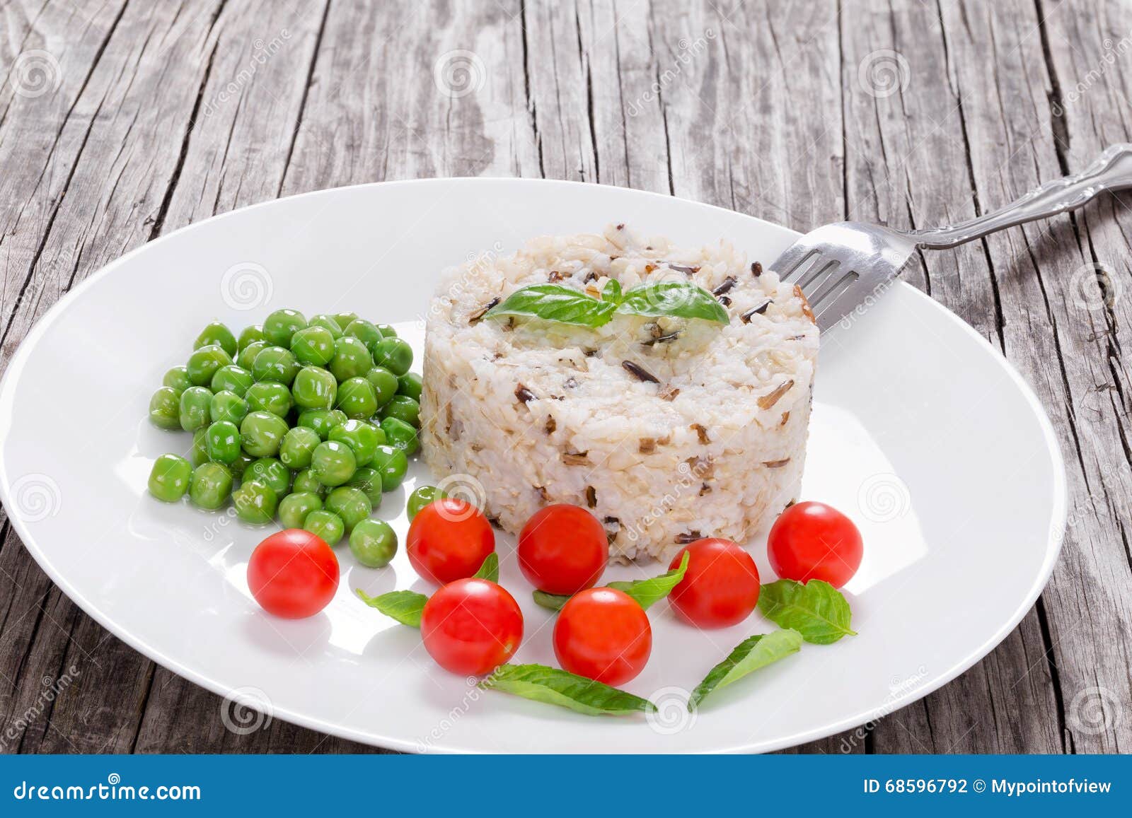 Brown and Wild Rice with Cherry Tomatoes, Green Peas Stock Photo