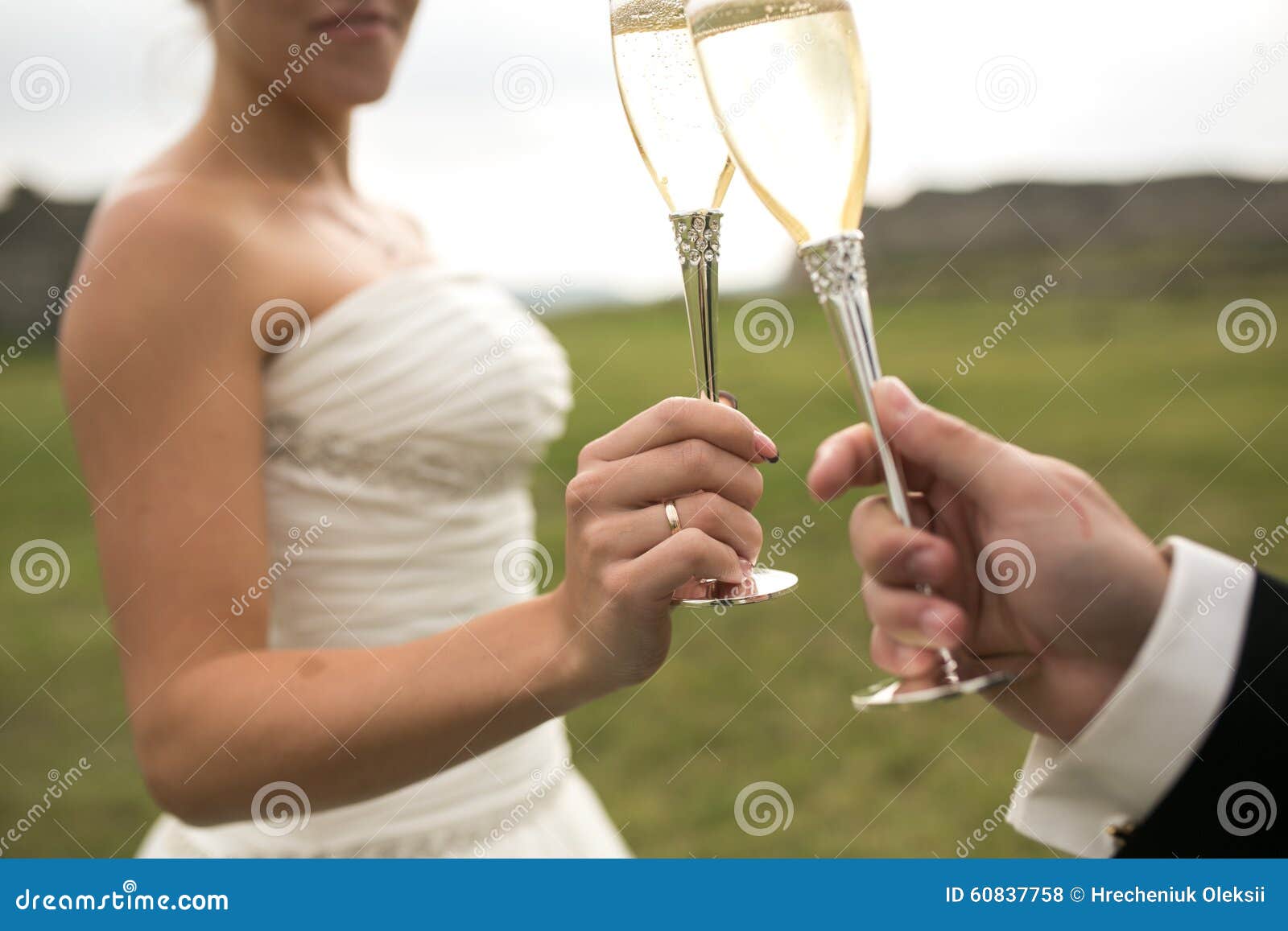 Brud- parfinkaexponeringsglas av champagne. Brud- par klirrar exponeringsglas av champagne på naturen