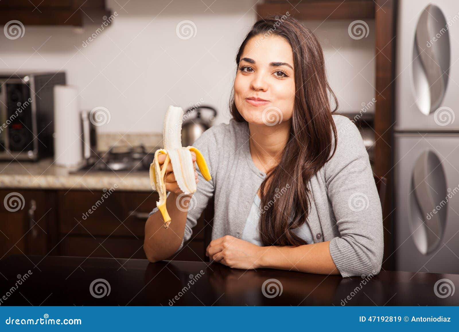Brune Mignonne Mangeant Une Banane Image stock Image du femme, pièce