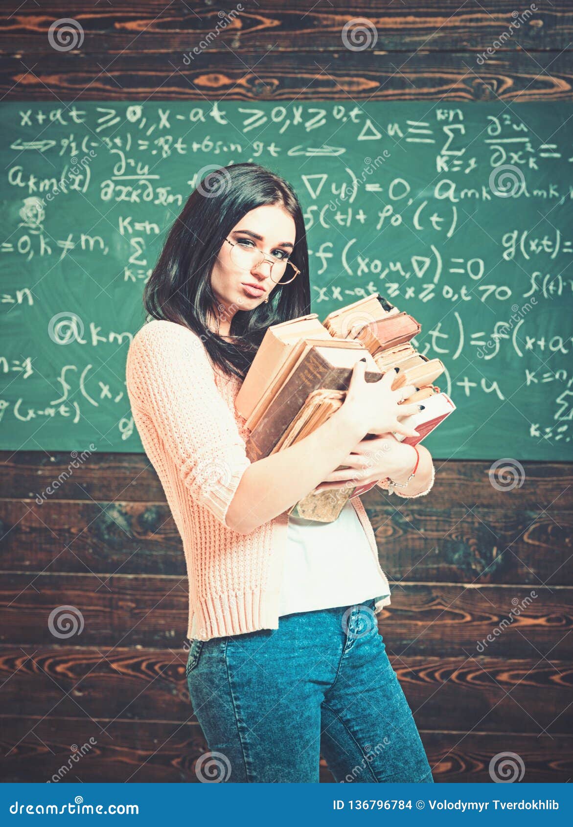 Brunette Female Student in Classroom. Young College Girl Walking with Two  Heaps of Books Stock Photo - Image of female, beautiful: 136796784