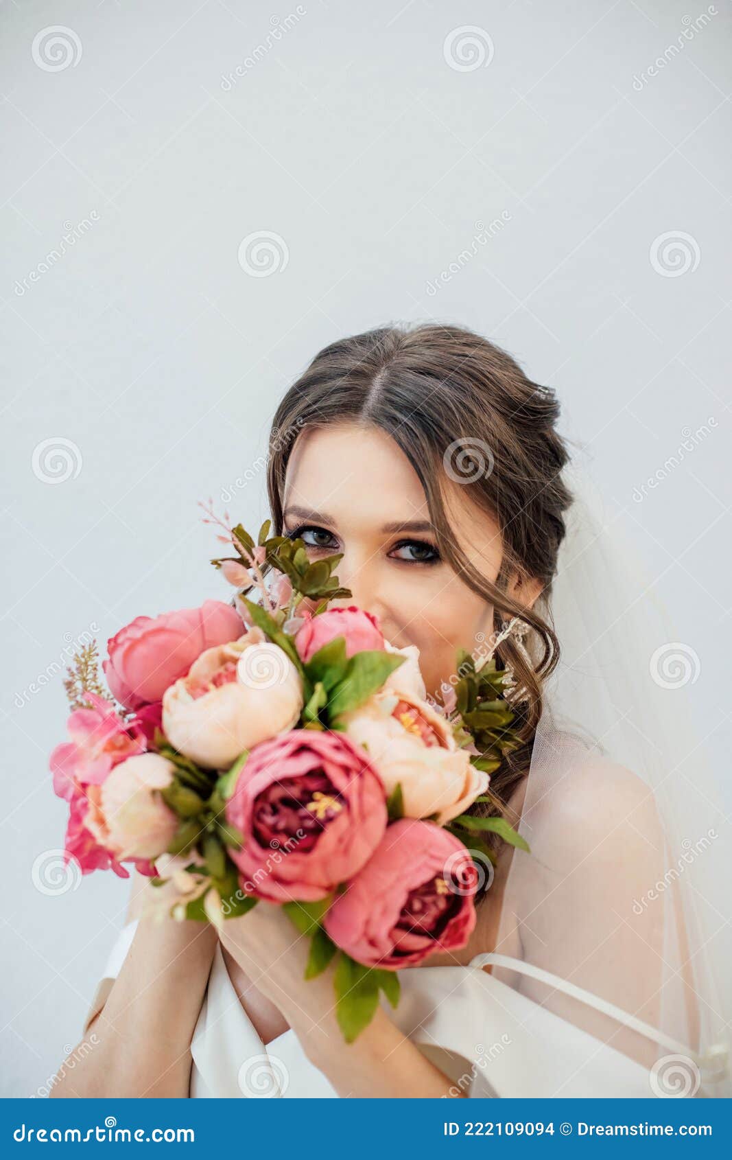 brunette girl in a wedding dress. bride in a white dress with a bouquet in her hands. makeup.