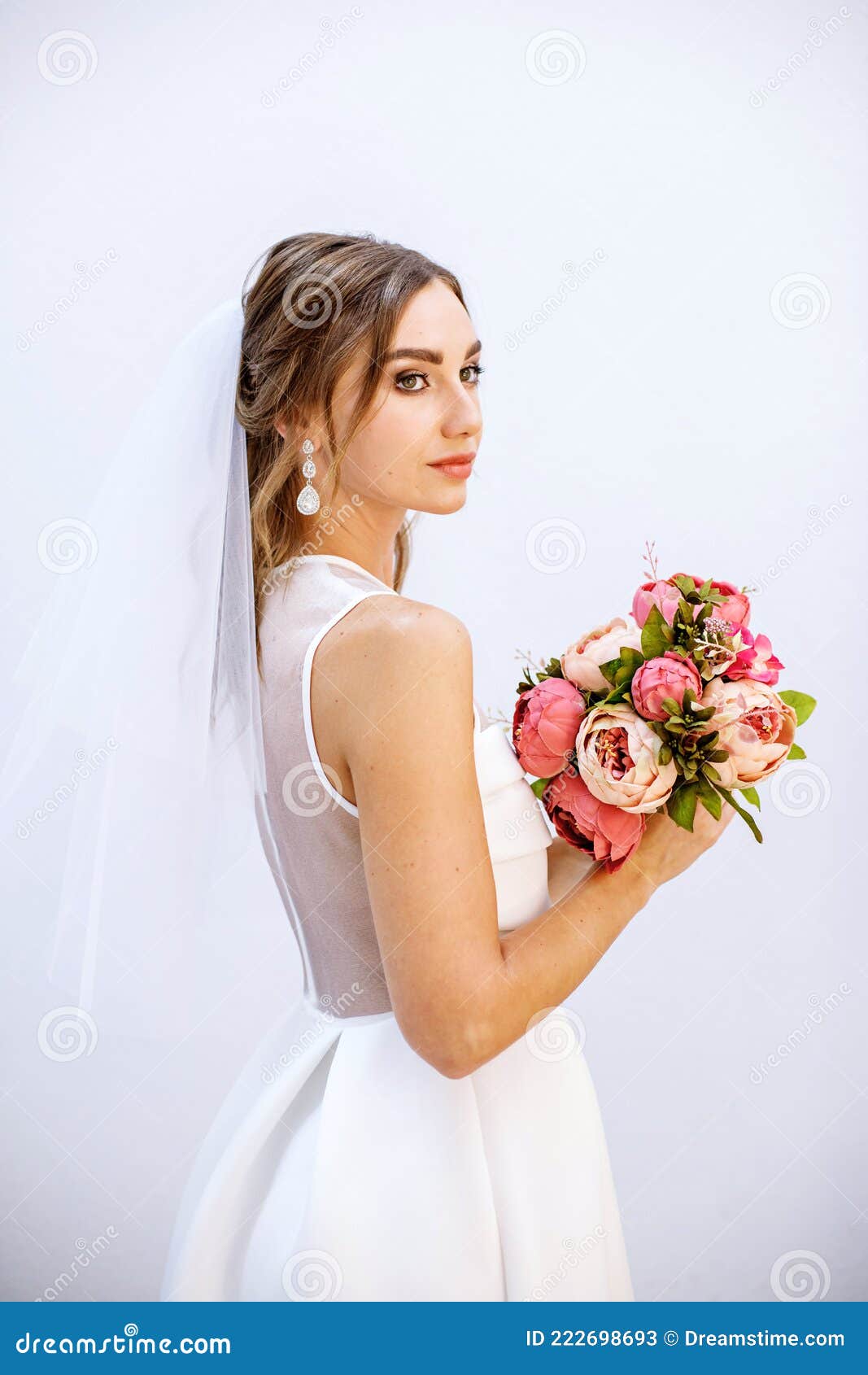 brunette girl in a wedding dress. bride in a white dress with a bouquet in her hands. makeup.
