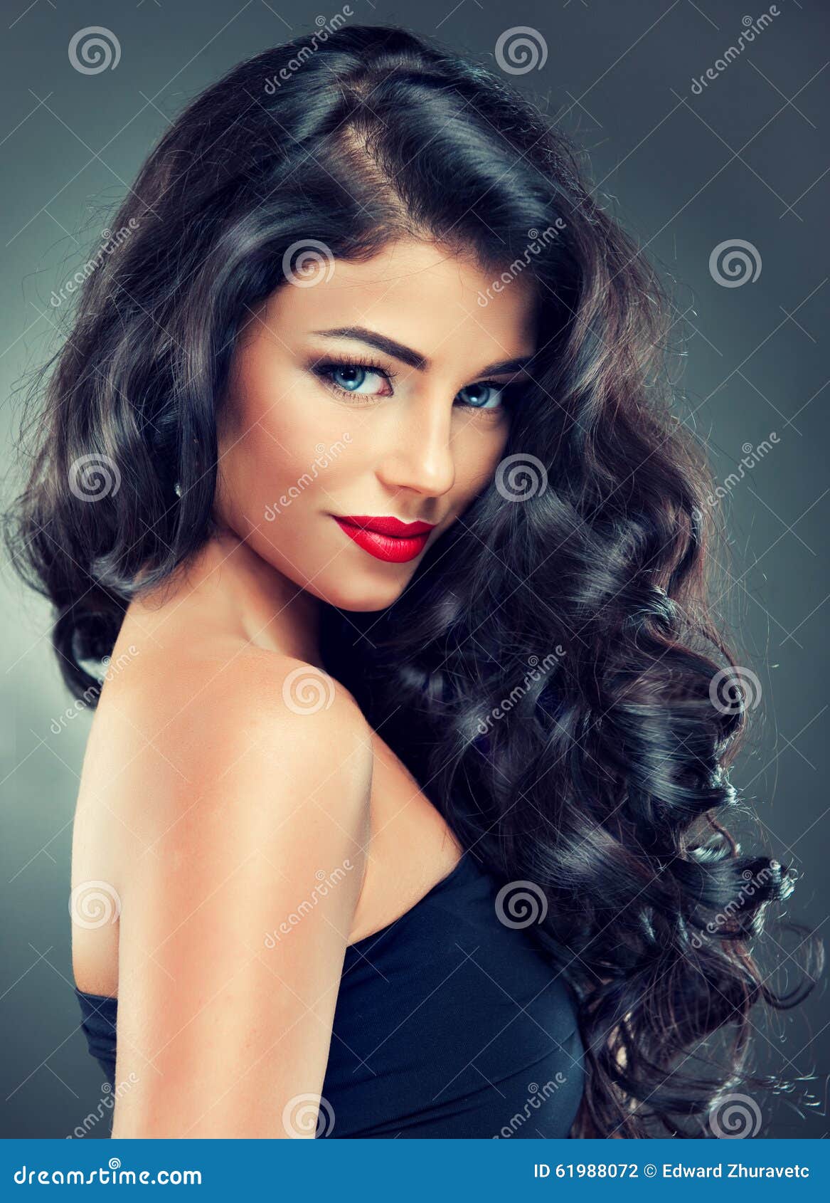 brunette with long, dense curly hair.
