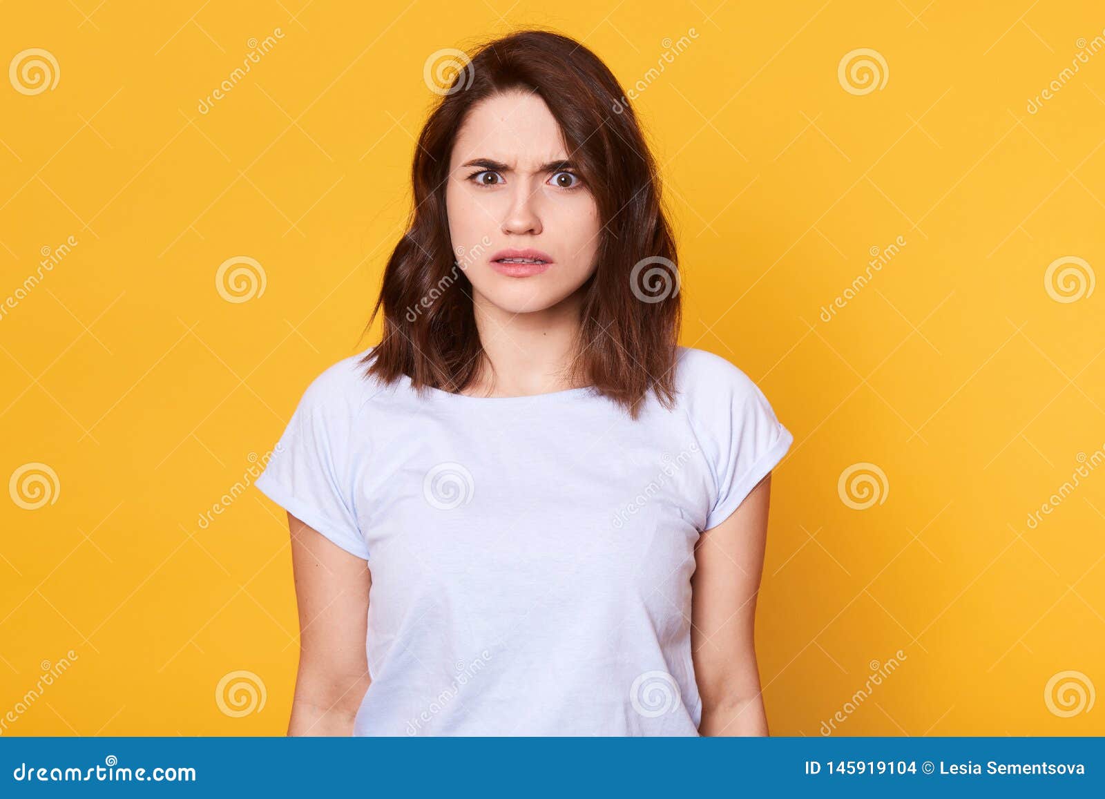 brunette woman in casual clothes expressing disgust, dislikes something, having tensive look frowning face. cauasian woman with