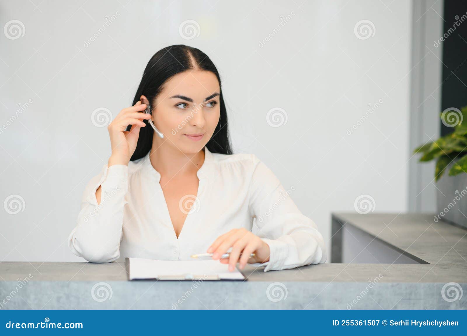 Brunette Woman Receptionist Working in Reception of the Beauty Salon Brunette Woman Receptionist Working in Reception of the Beauty Salon