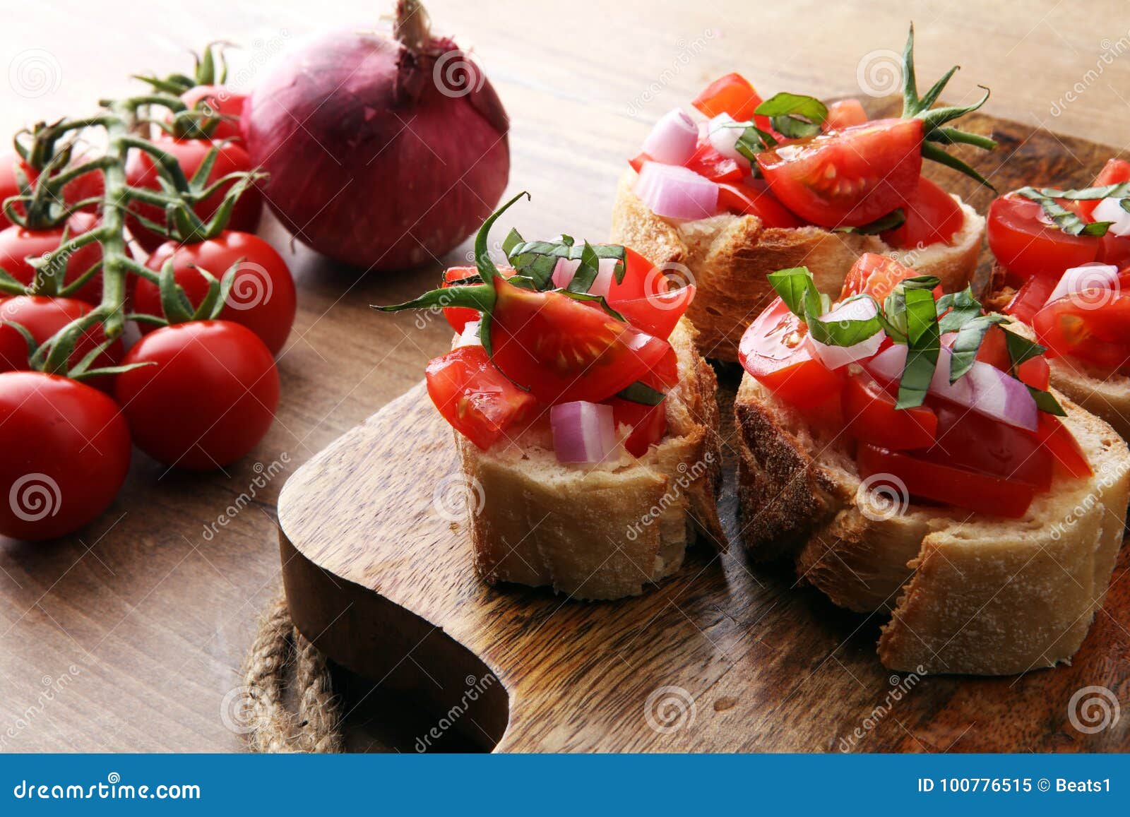 Bruschetta mit Tomaten, Kräutern und Öl auf geröstetem Knoblauchkäse. Toastbrot mit gehackten Tomaten auf hölzernem Schneidebrett