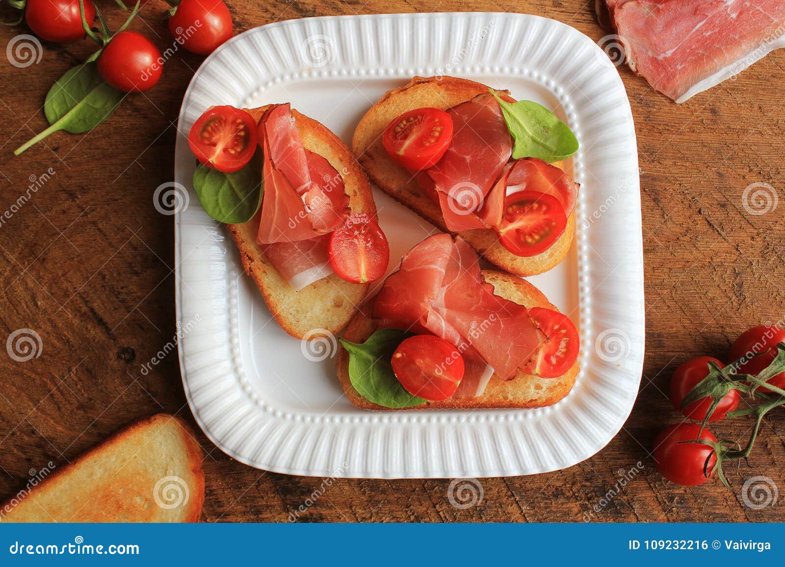 Bruschetta with Prosciutto Ham, Cherry Tomatoes and Green Spinach . Top