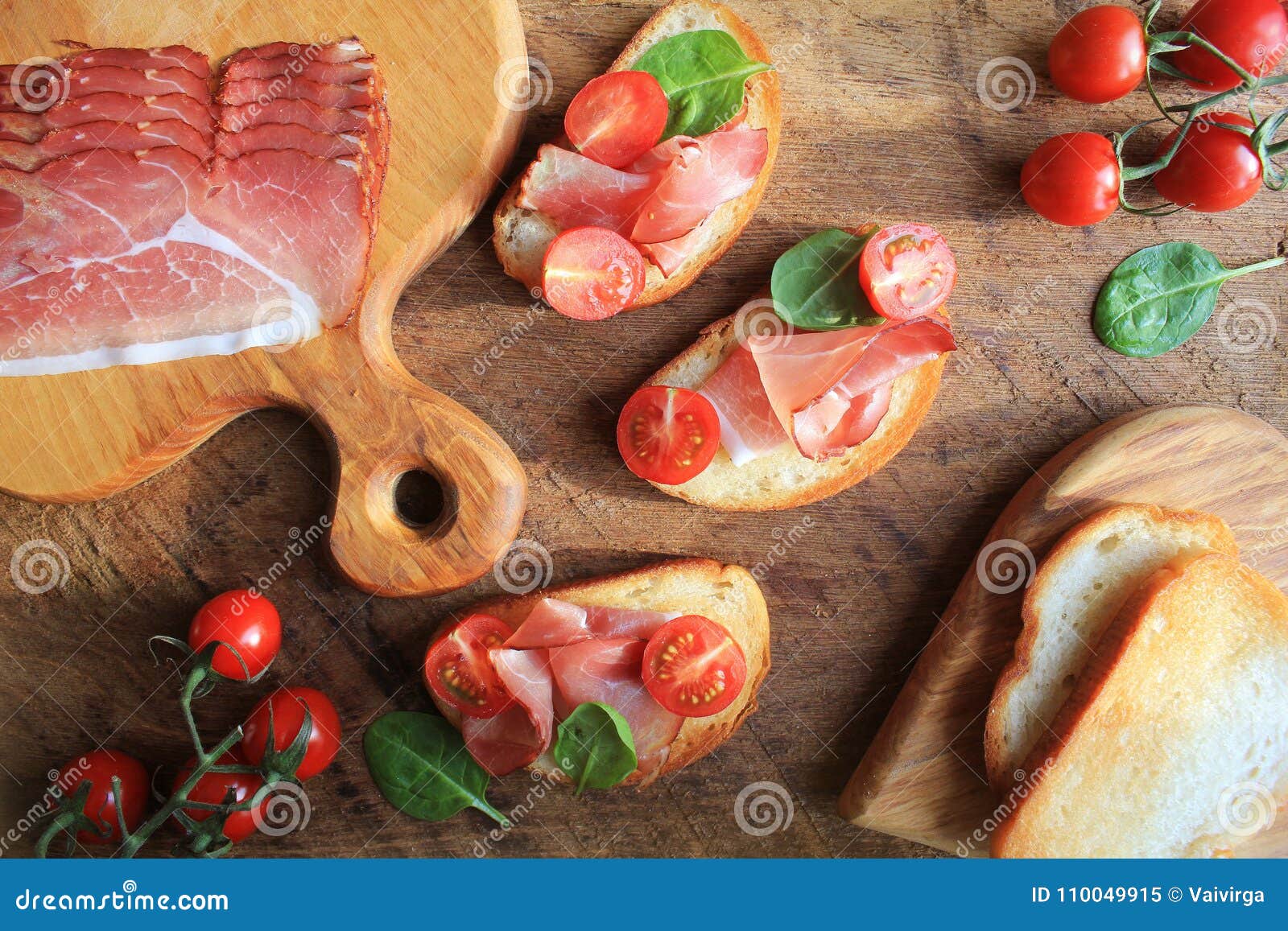 Bruschetta with Prosciutto Ham, Cherry Tomatoes and Green Spinach . Top