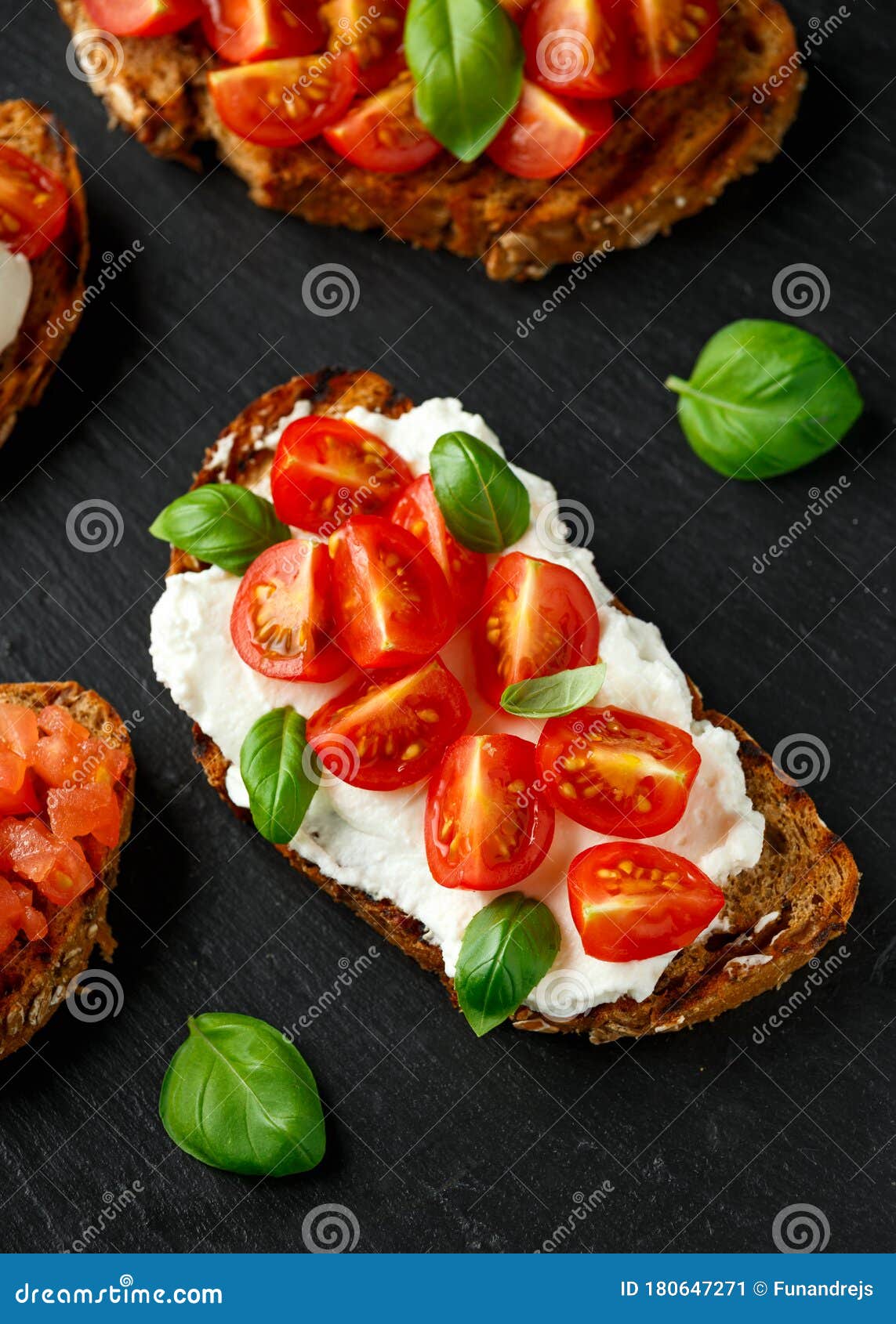 Bruschetta with Ricotta Cheese, Basil, Cherry Tomato on Rustic Stone