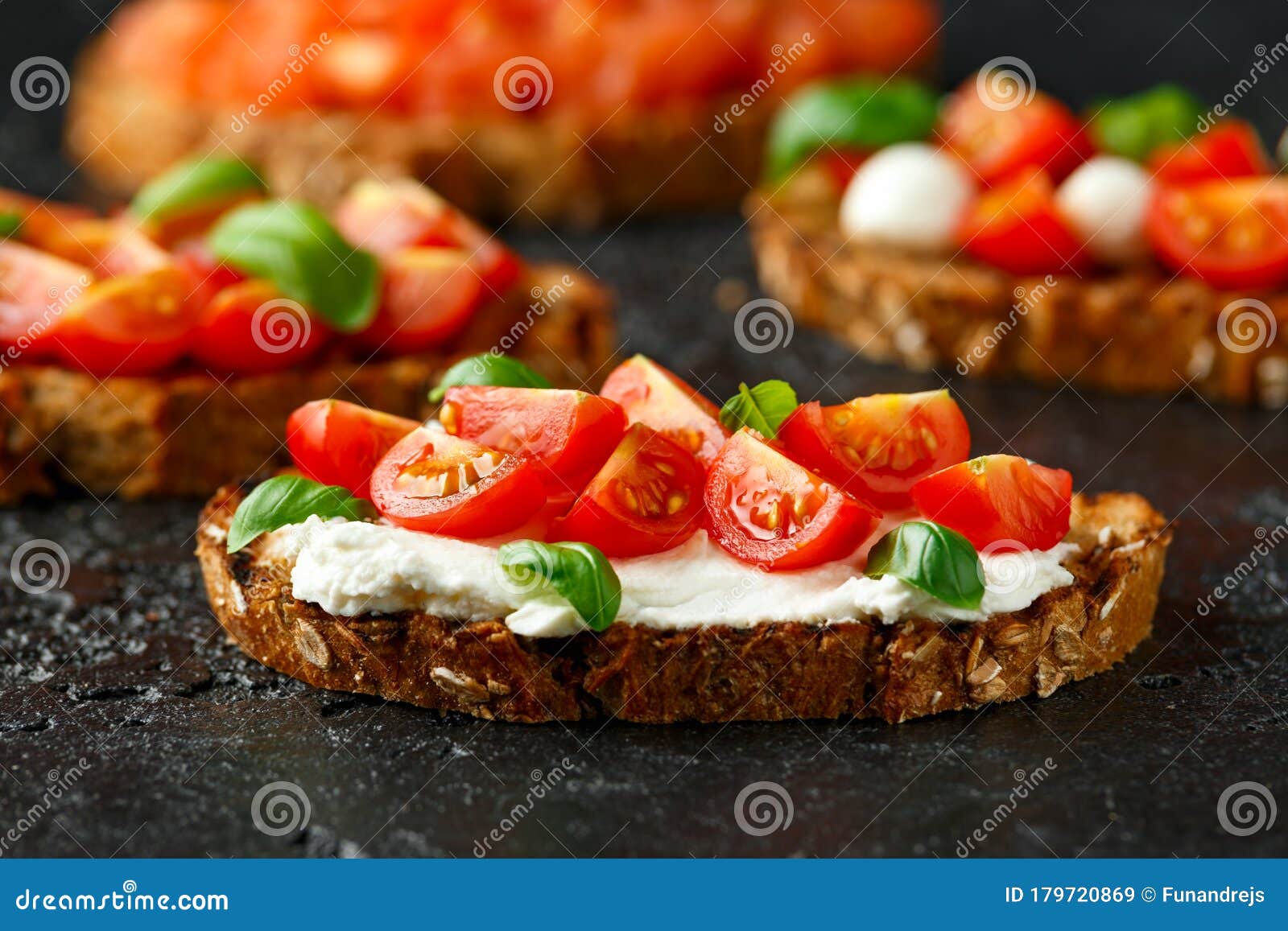 Bruschetta with Ricotta Cheese, Basil, Cherry Tomato on Rustic Table