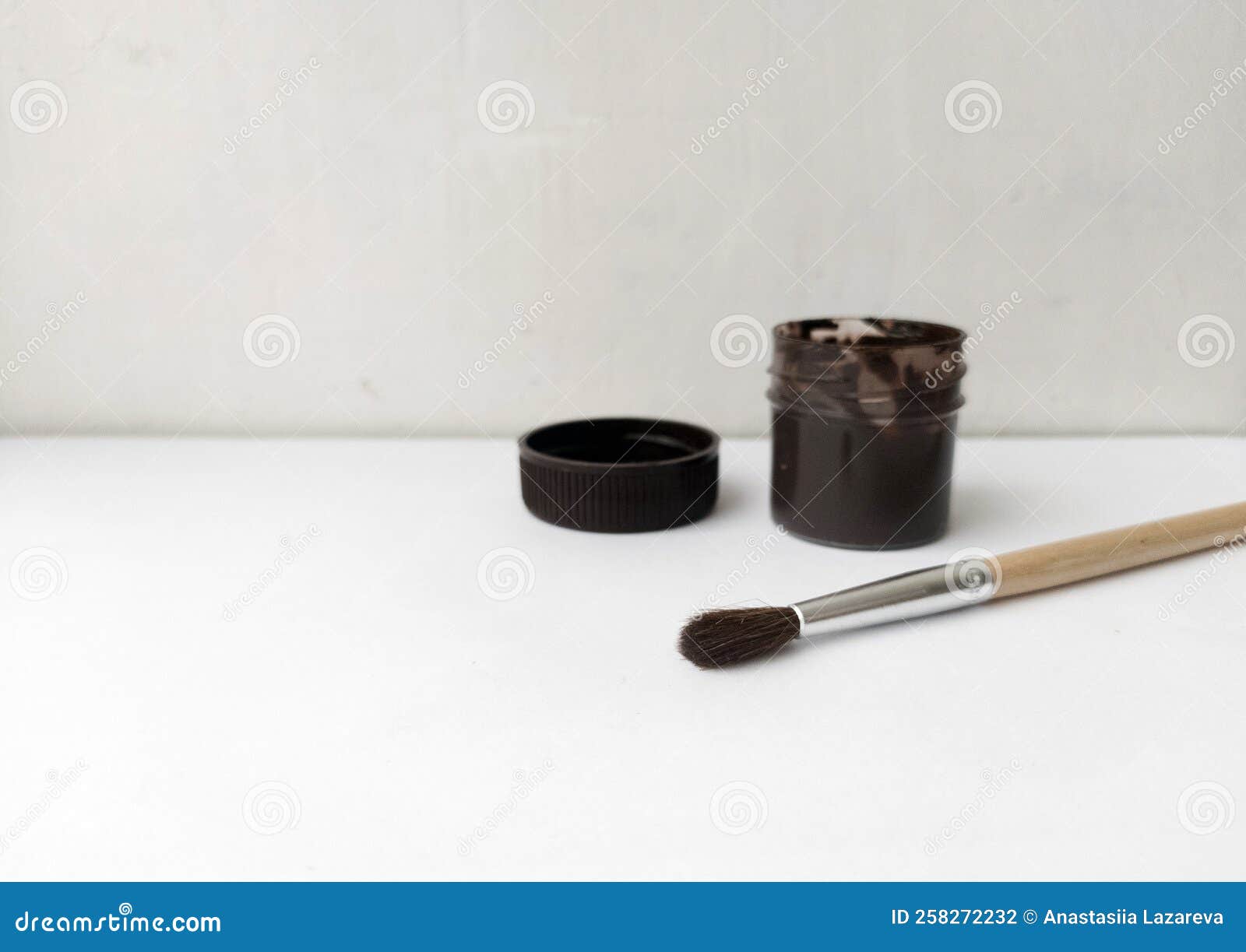 Brush and Can with Black Paint on a White Background. the Paint is Open