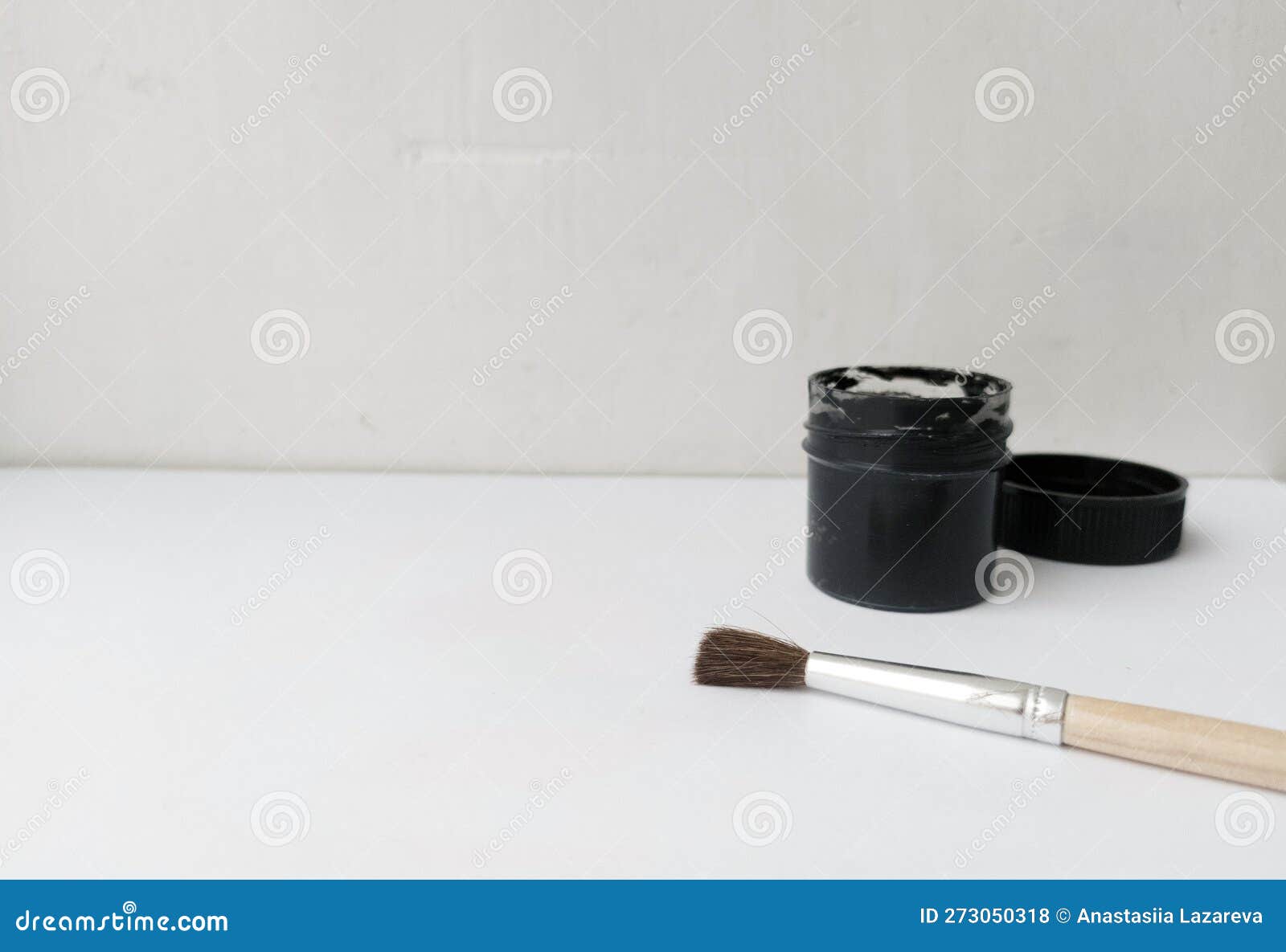 Brush and Can with Black Paint on a White Background. the Paint is Open