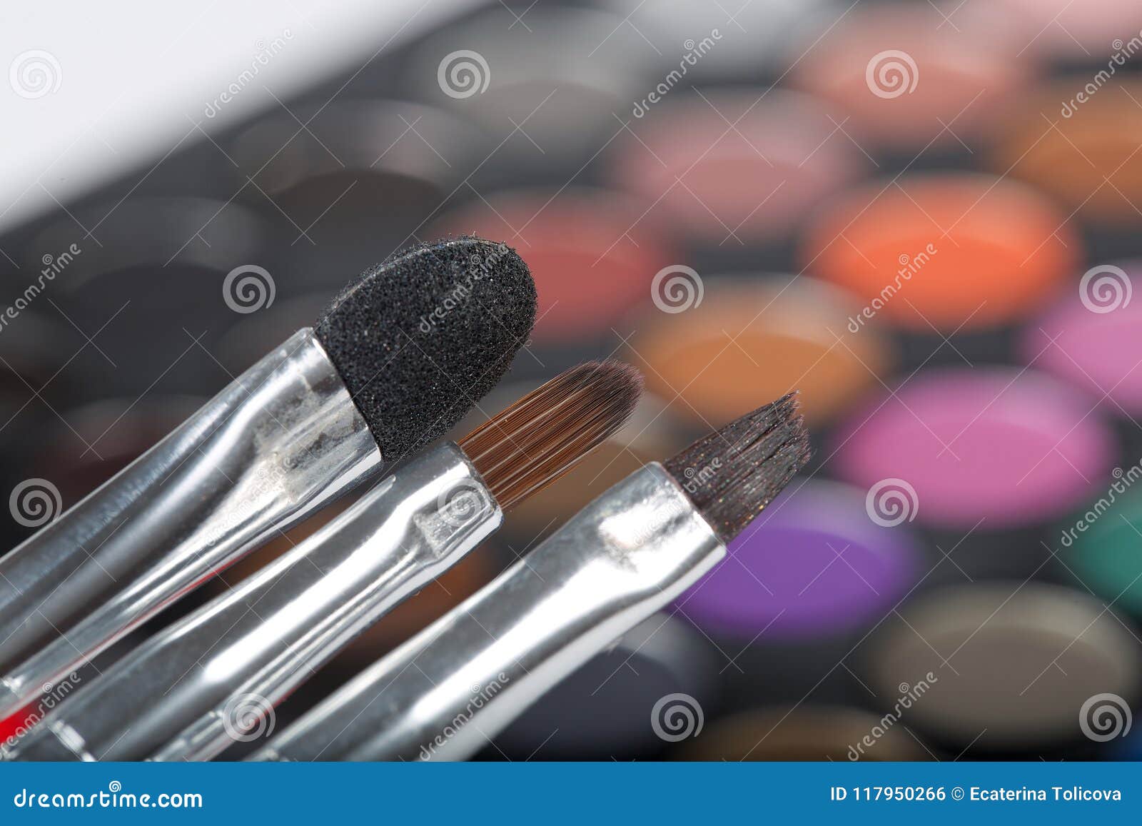 brushes kit. makeup palette of eye shadows in the background