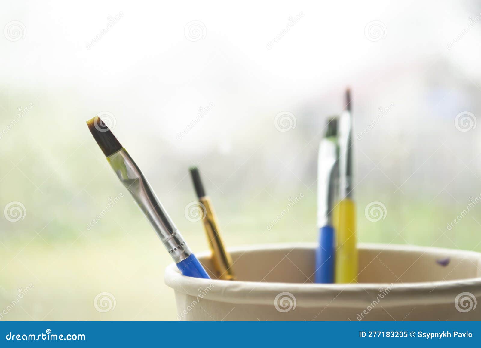 Brushes in a Paper Cup. Paint Brushes are Wet after Use. Four Paint