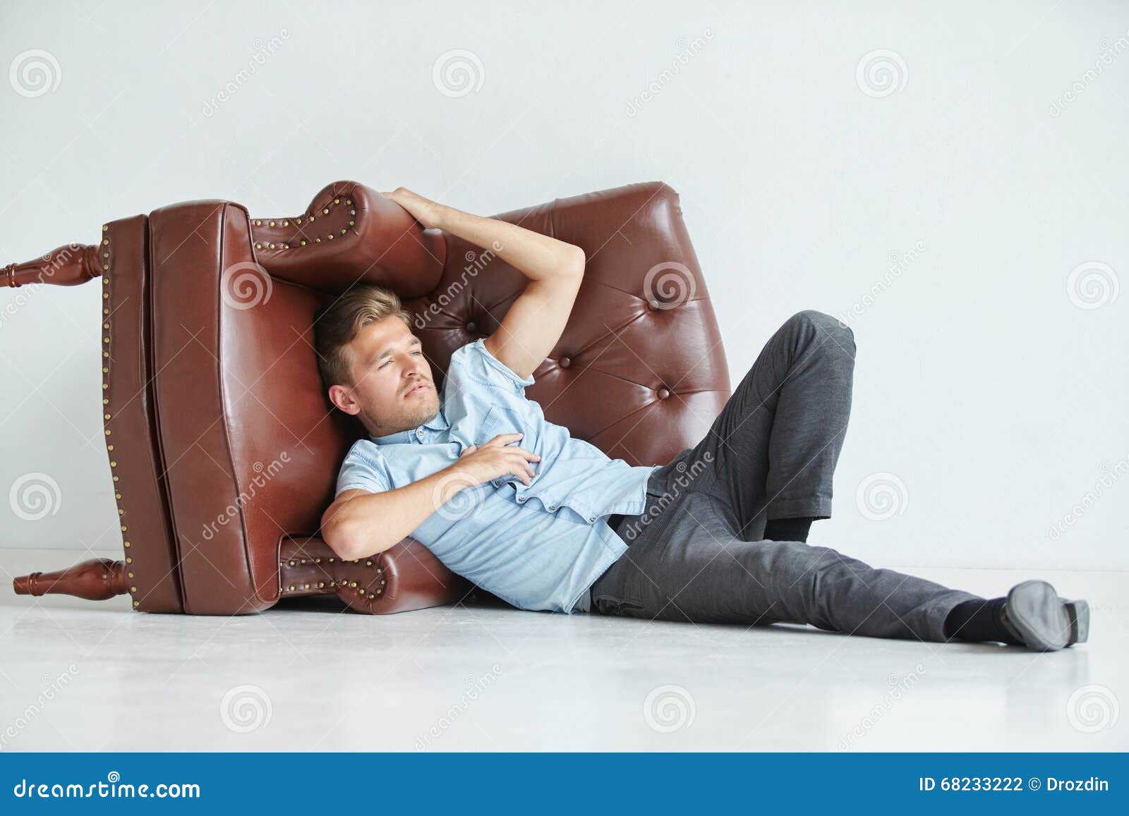 Brutal Man Lying Next To a Brown Leather Armchair Stock Photo - Image ...