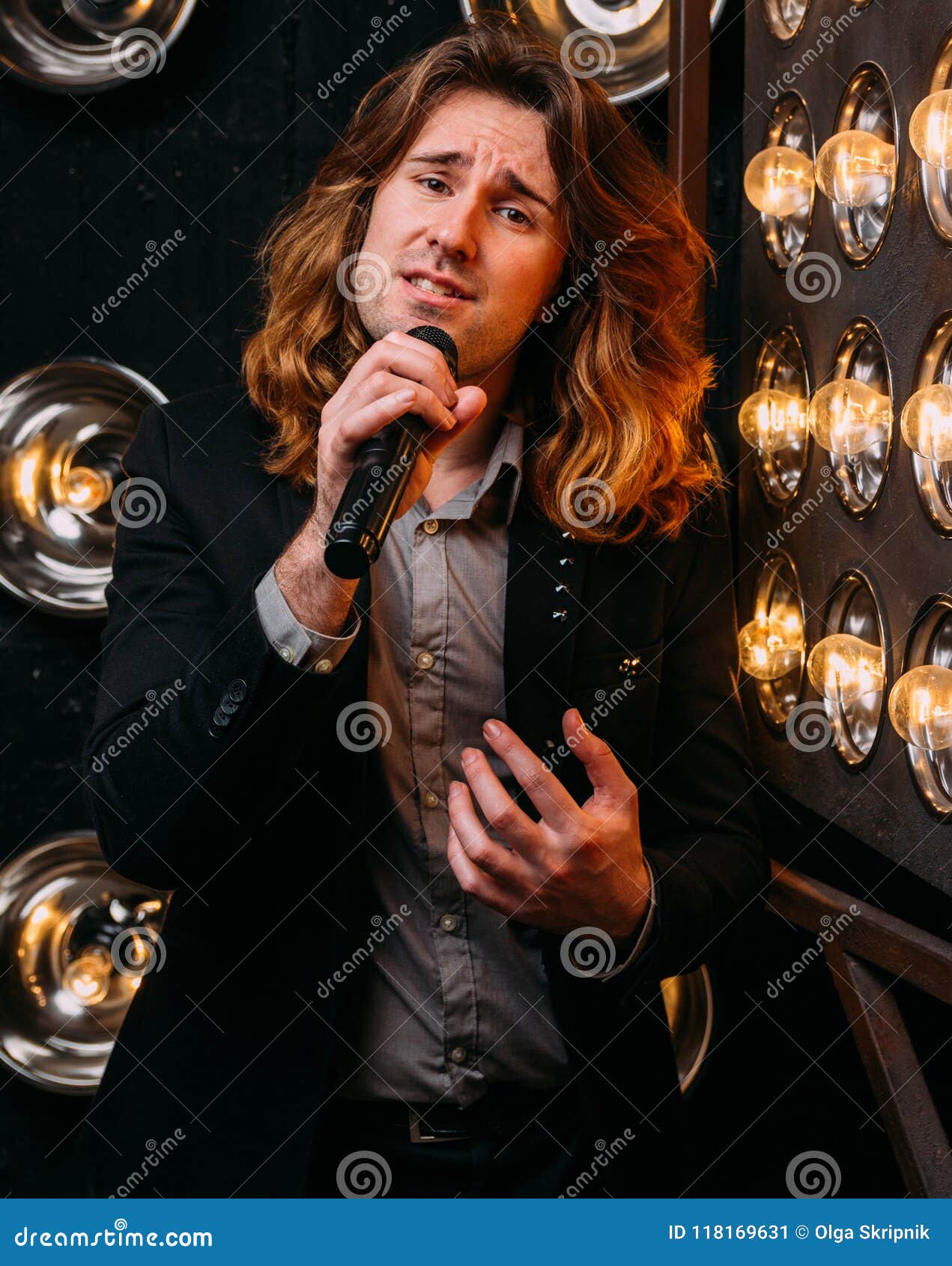 Brutal Singer with Long Hair, with Microphone on the Stage Stock Image