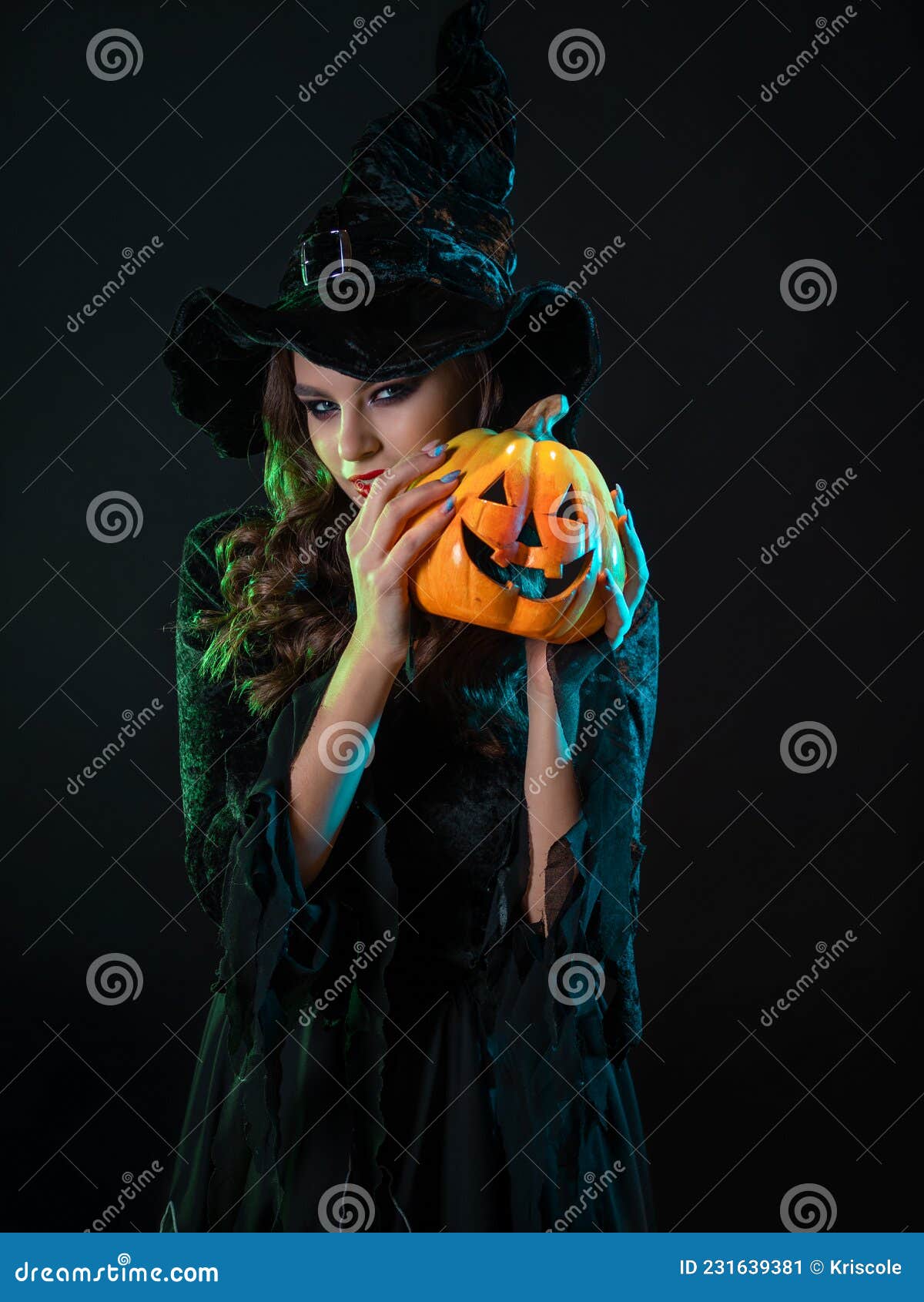 Uma Jovem Bruxa Bonita Em Um Chapéu Cônico Segura Uma Abóbora De Halloween  Em Suas Mãos E Faz Um Feitiço Com Sua Mão. Foto Royalty Free, Gravuras,  Imagens e Banco de fotografias.